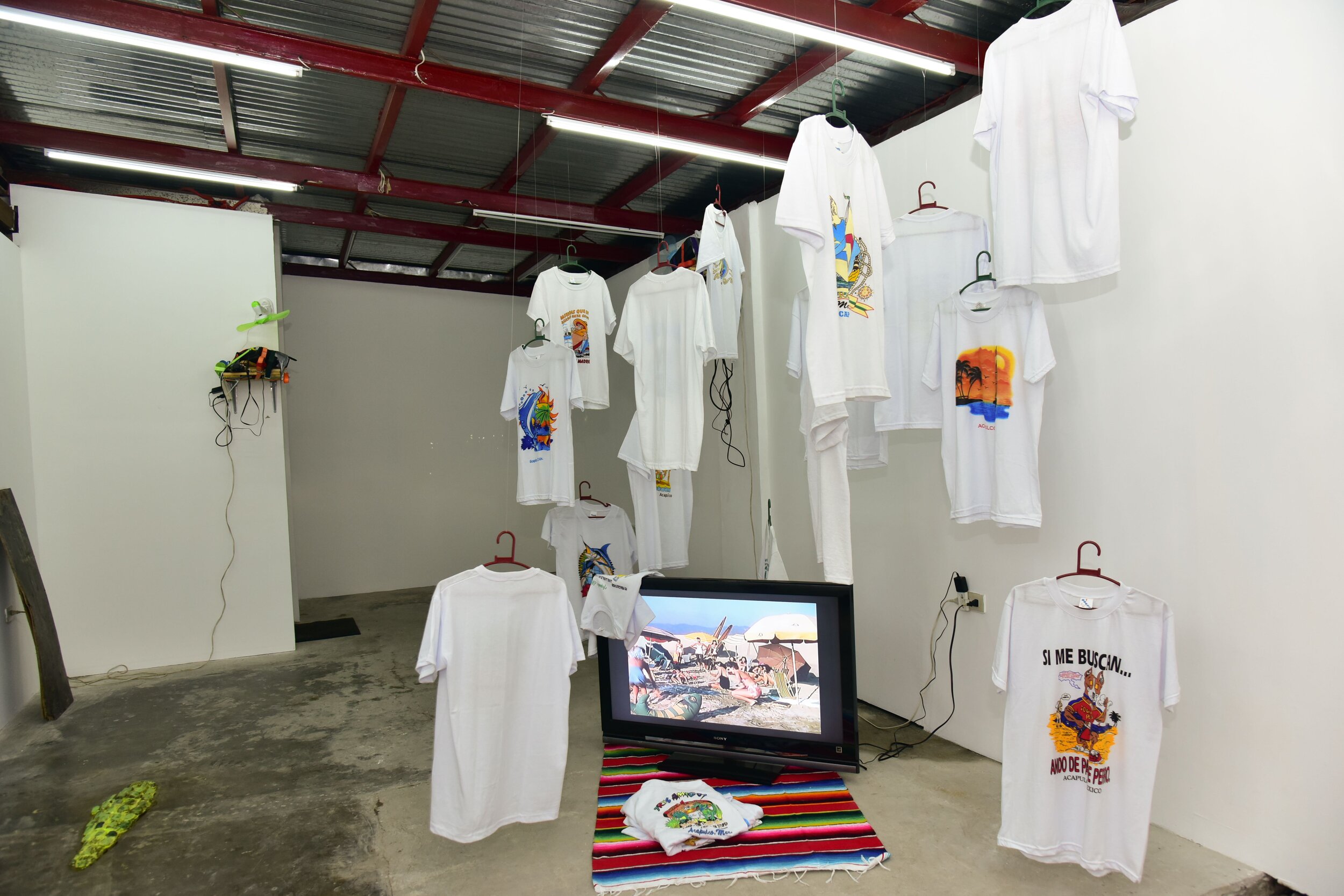 Cristóbal Gracia, "Nos Value Madres", 2019, mixed media, touristic t-shirts from Acapulco, sarape blanket; "Tres Amigos, the good, the bad and the stuped" video loop (3:35 mins) 