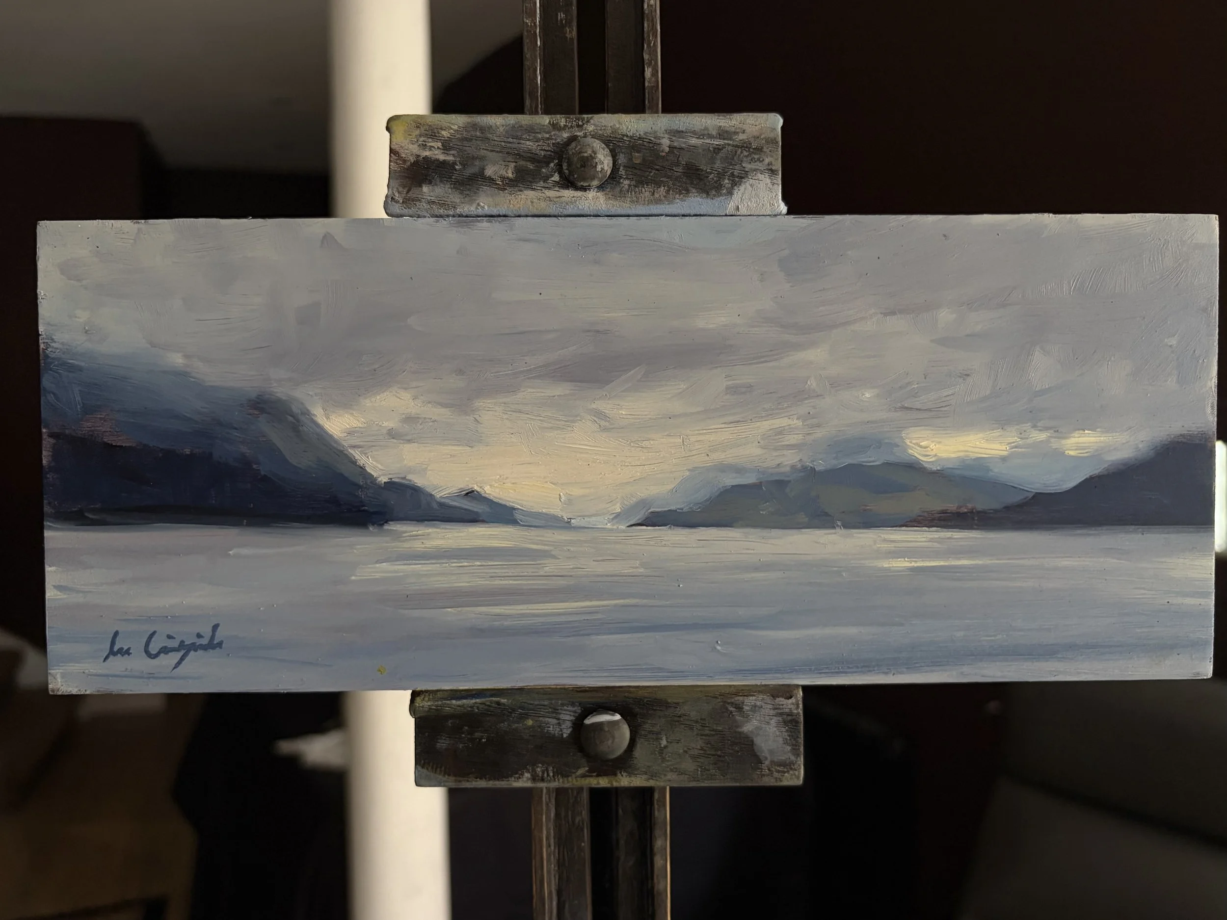 Original oil painting of Loch Ness from Dores displayed on a studio easel by Scottish artist Lee Craigmile.
