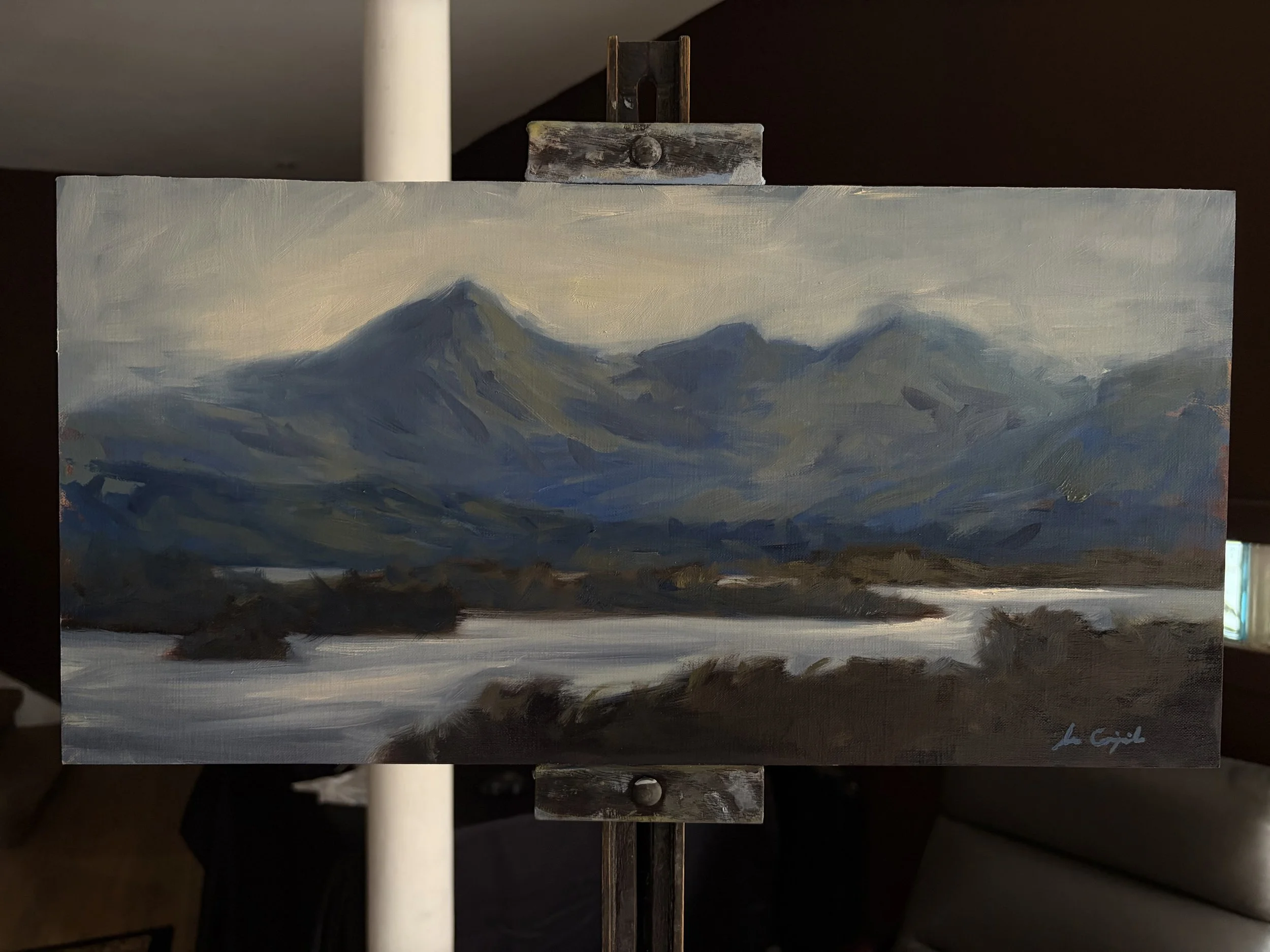 Original oil painting of the Cuillin Hills displayed on a studio easel by Scottish artist Lee Craigmile.