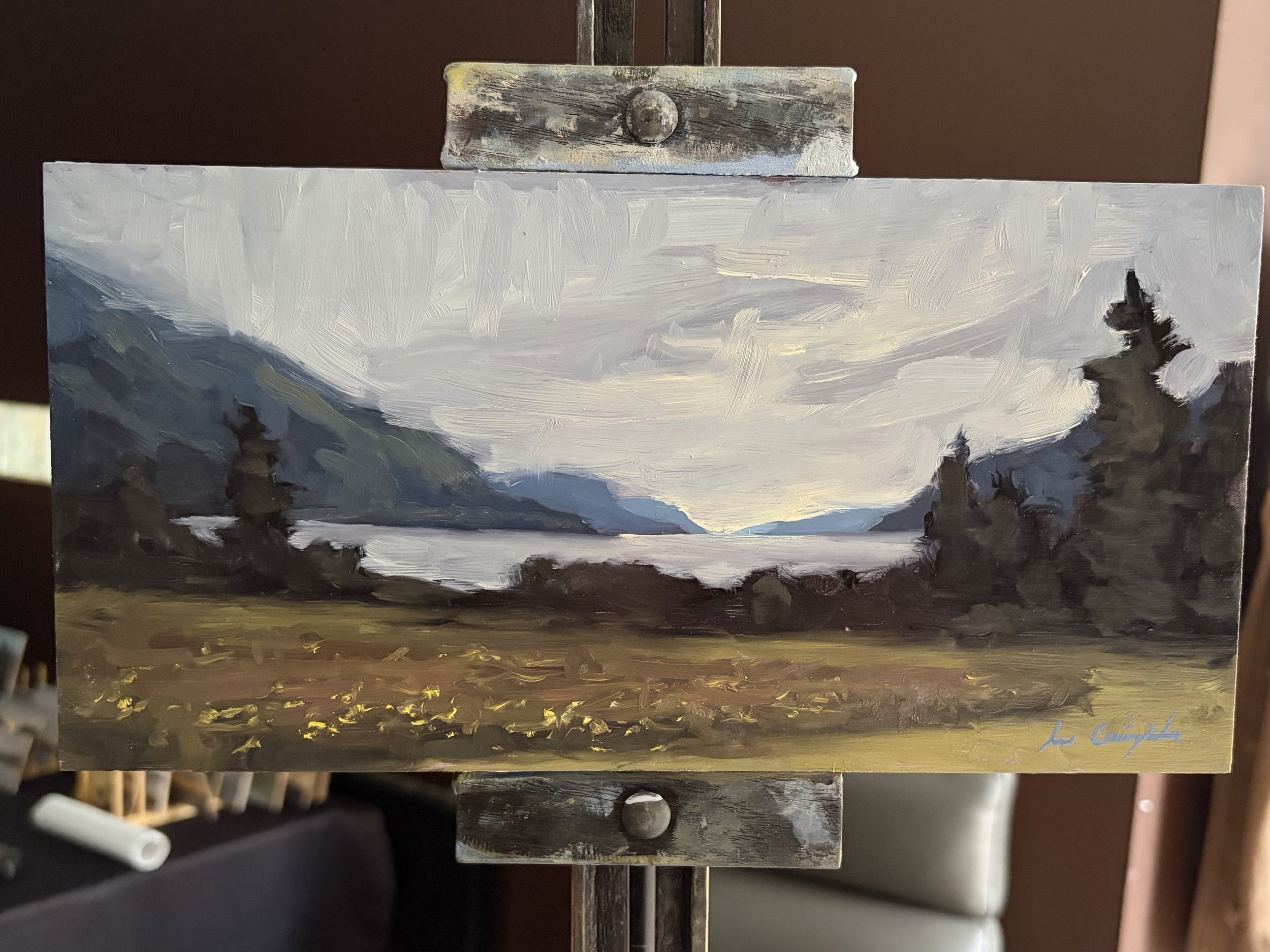 Original oil painting of Loch Ness from Dores displayed on a studio easel by Scottish artist Lee Craigmile.