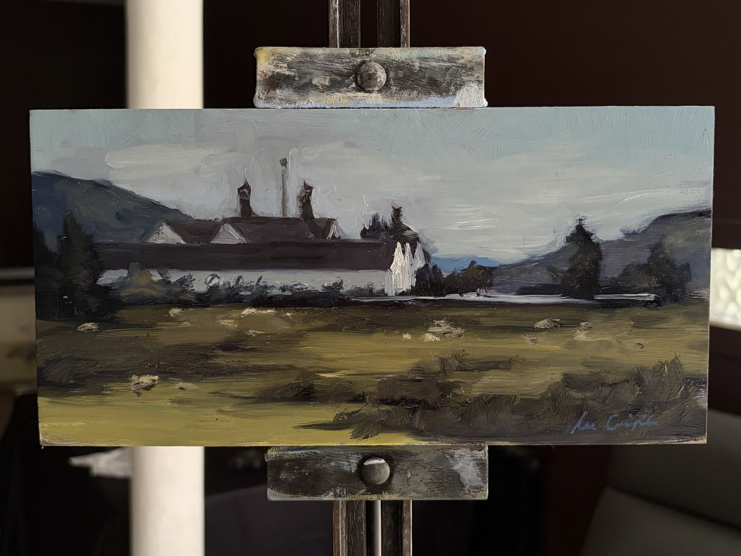 Original oil painting of Dalwhinnie Distillery displayed on a studio easel by Scottish artist Lee Craigmile.