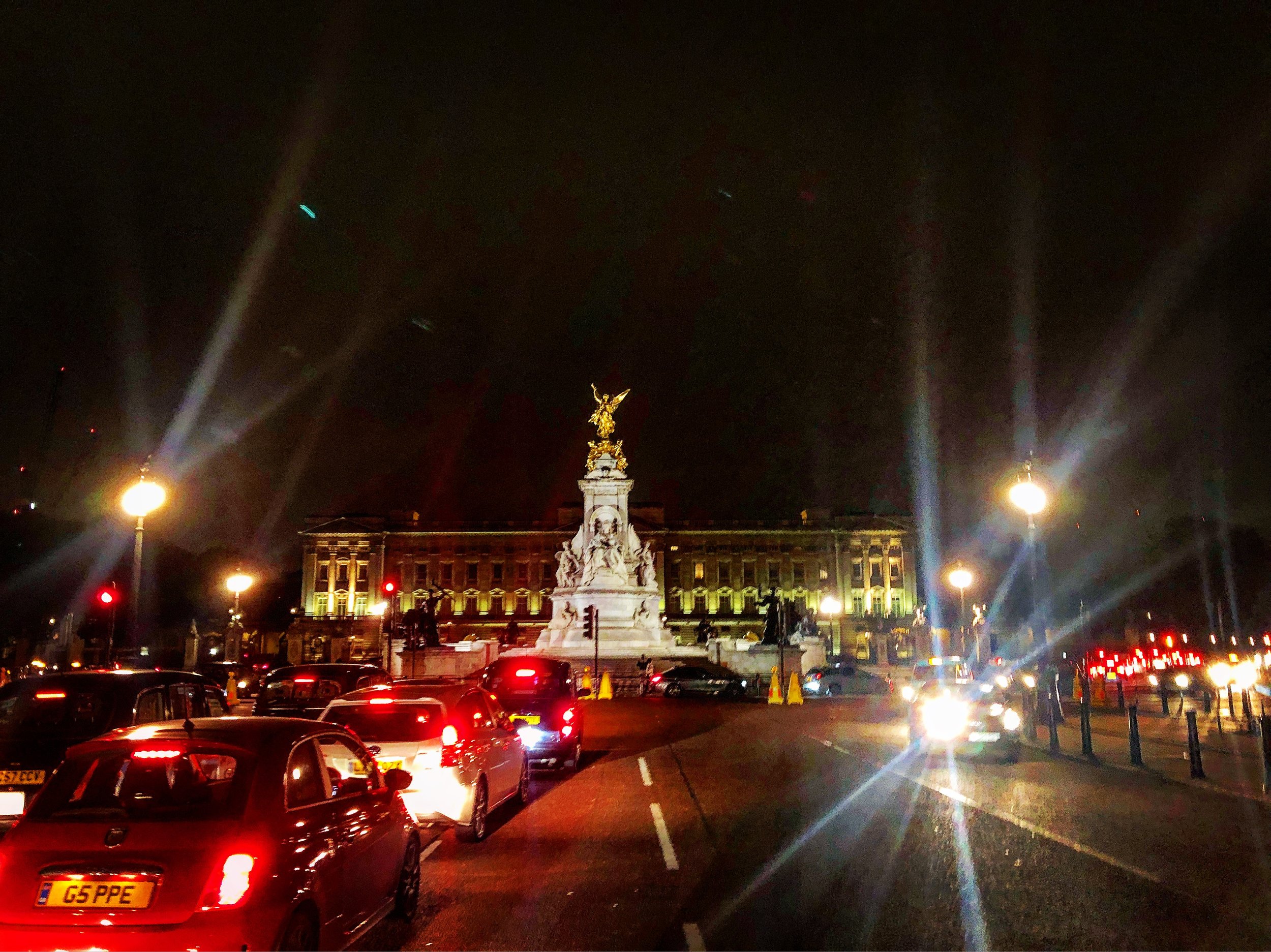 Buckingham Palace at night with cars and lights