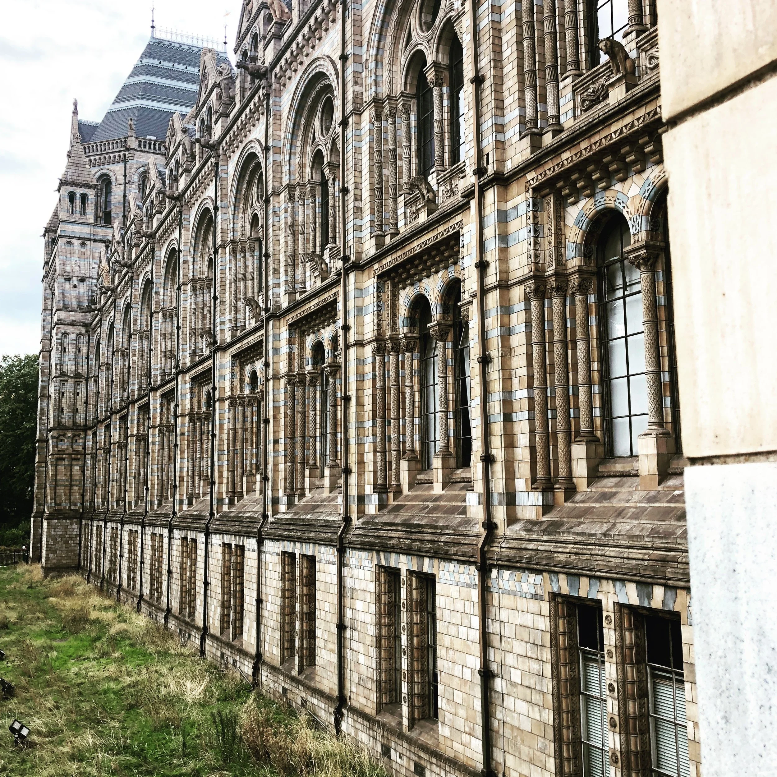Exterior of historic stone building with arched windows and detailed architectural features.