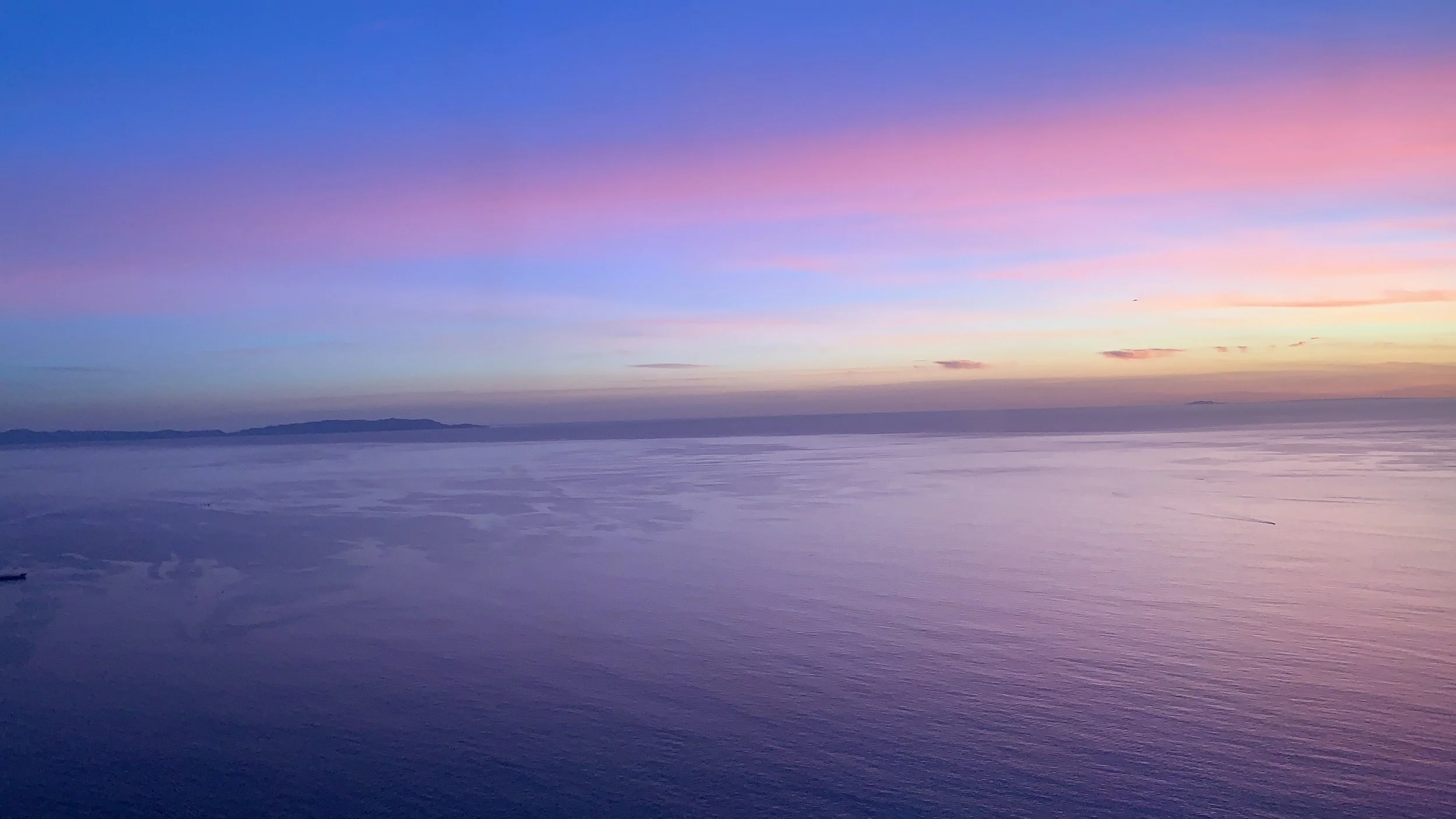 Sunset over ocean with pink and blue sky