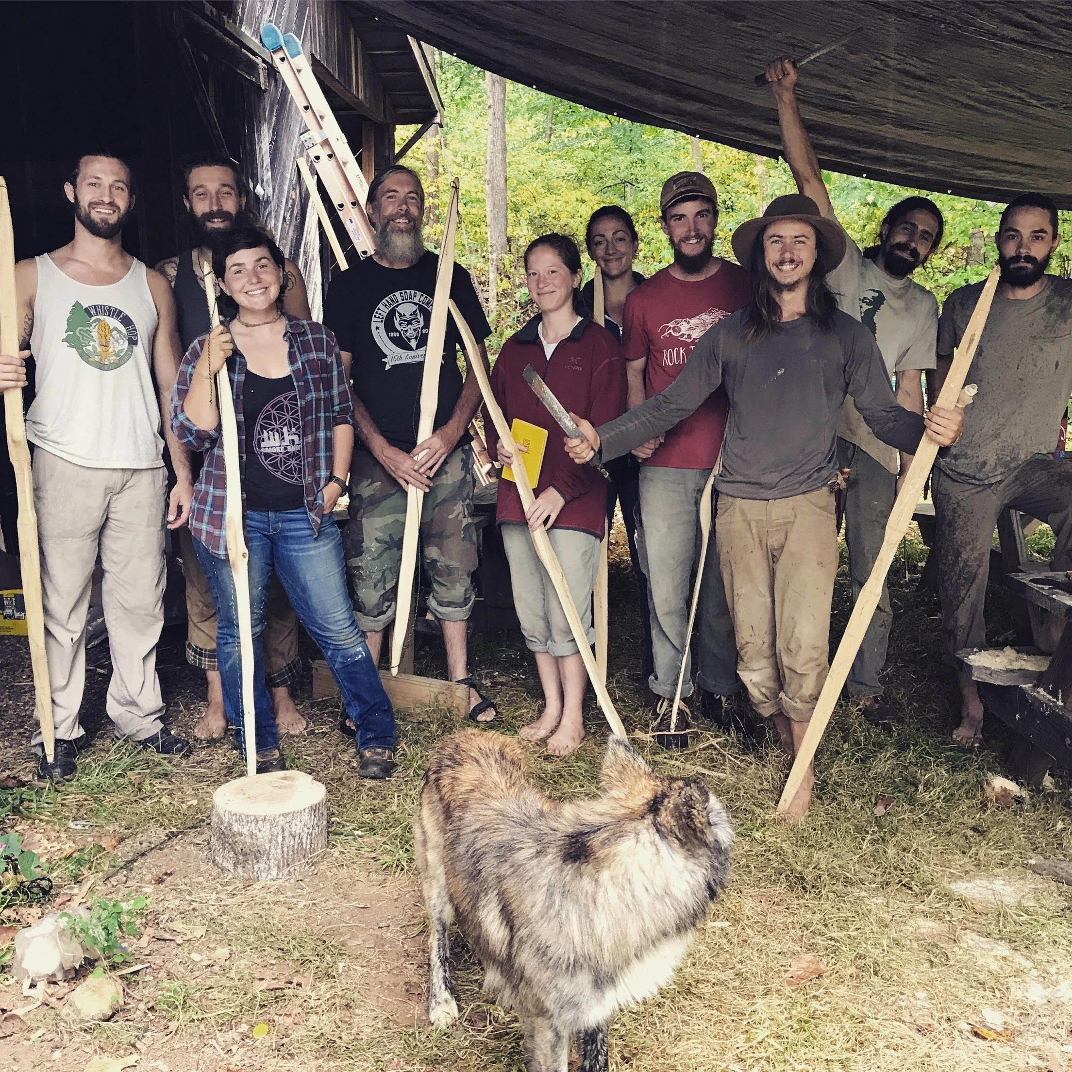 A group of students holding the handmade archery bows they are working on