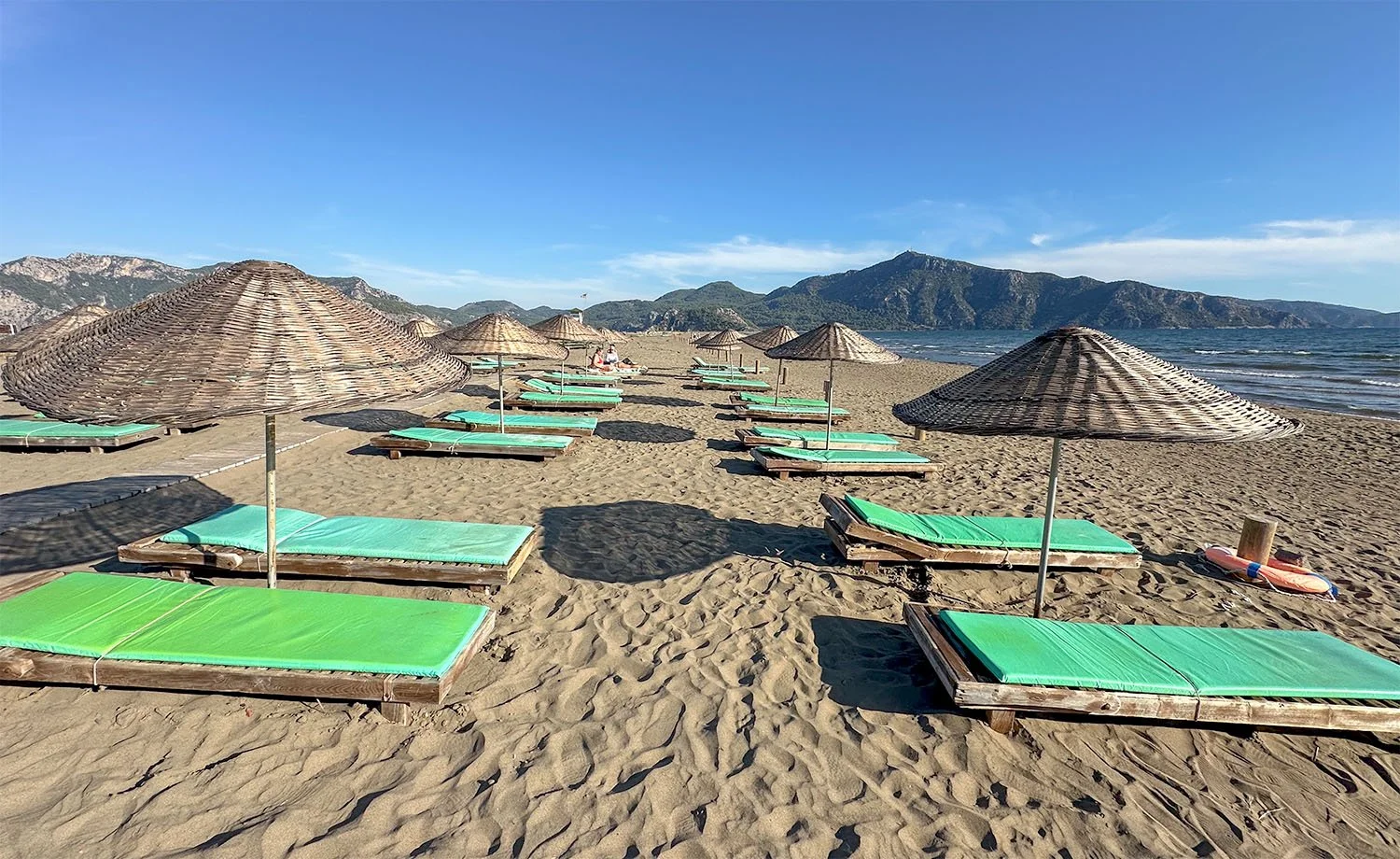 Empty sunbeds and sunshades lined up along Iztuzu Beach on the Turkish Riviera, Türkiye.