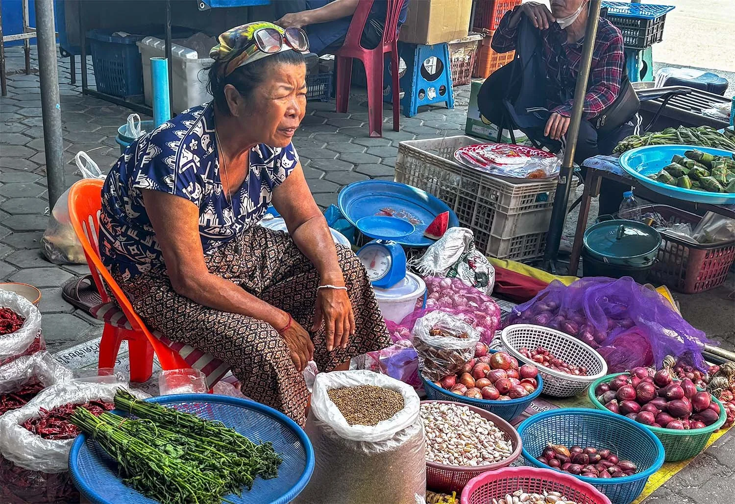Elderly vegetable sellers waiting for customers in a village market near Chiang Mai in Thailand.