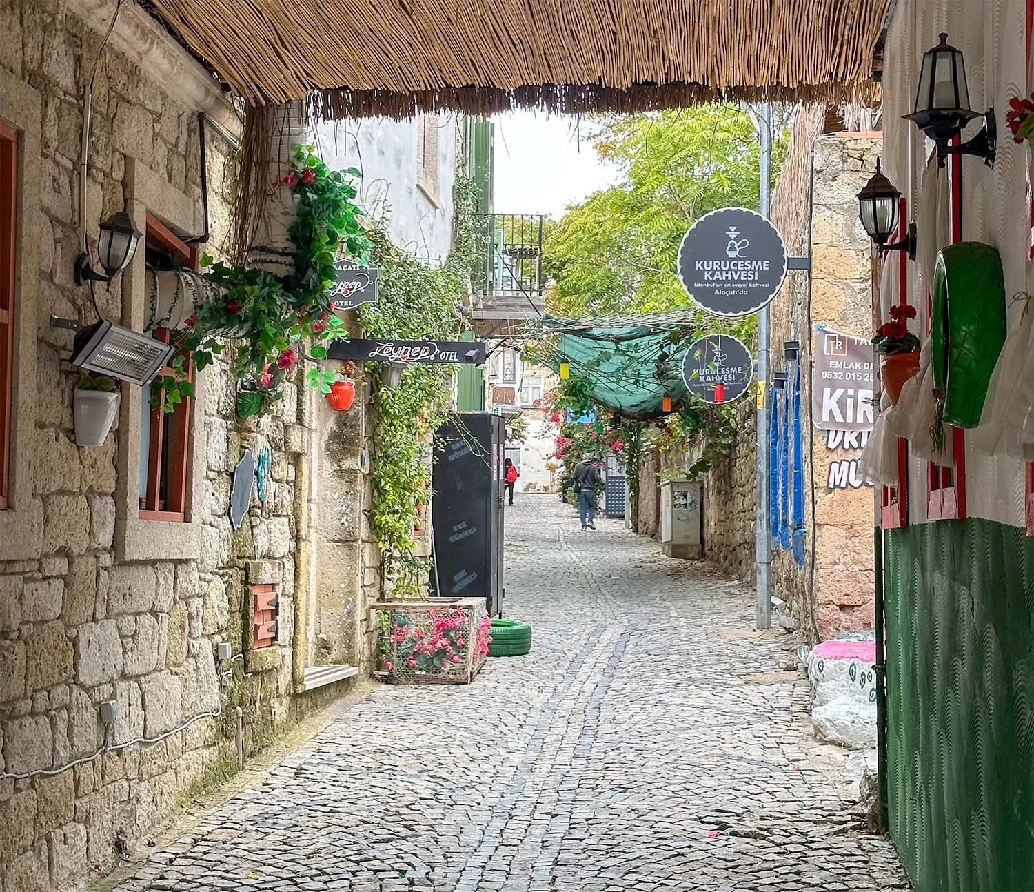 A narrow cobblestone street between traditional stone house at Alaçatı, Türkiye.
