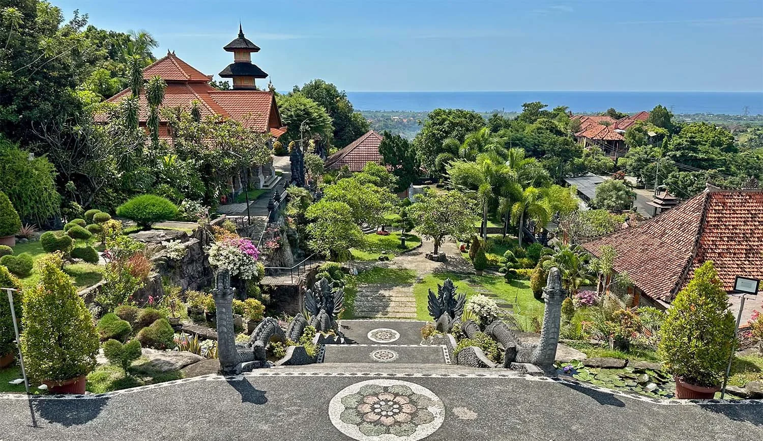 View looking over part of the gardens of the Brahmavihara-Arama monastery in North Bali with the ocean on the horizon.