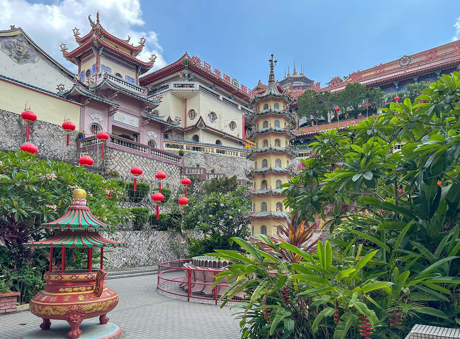Traditional Chinese Buddhist temple buildings surround a courtyard at Kek Lok Si on Penang Island, Malaysia.