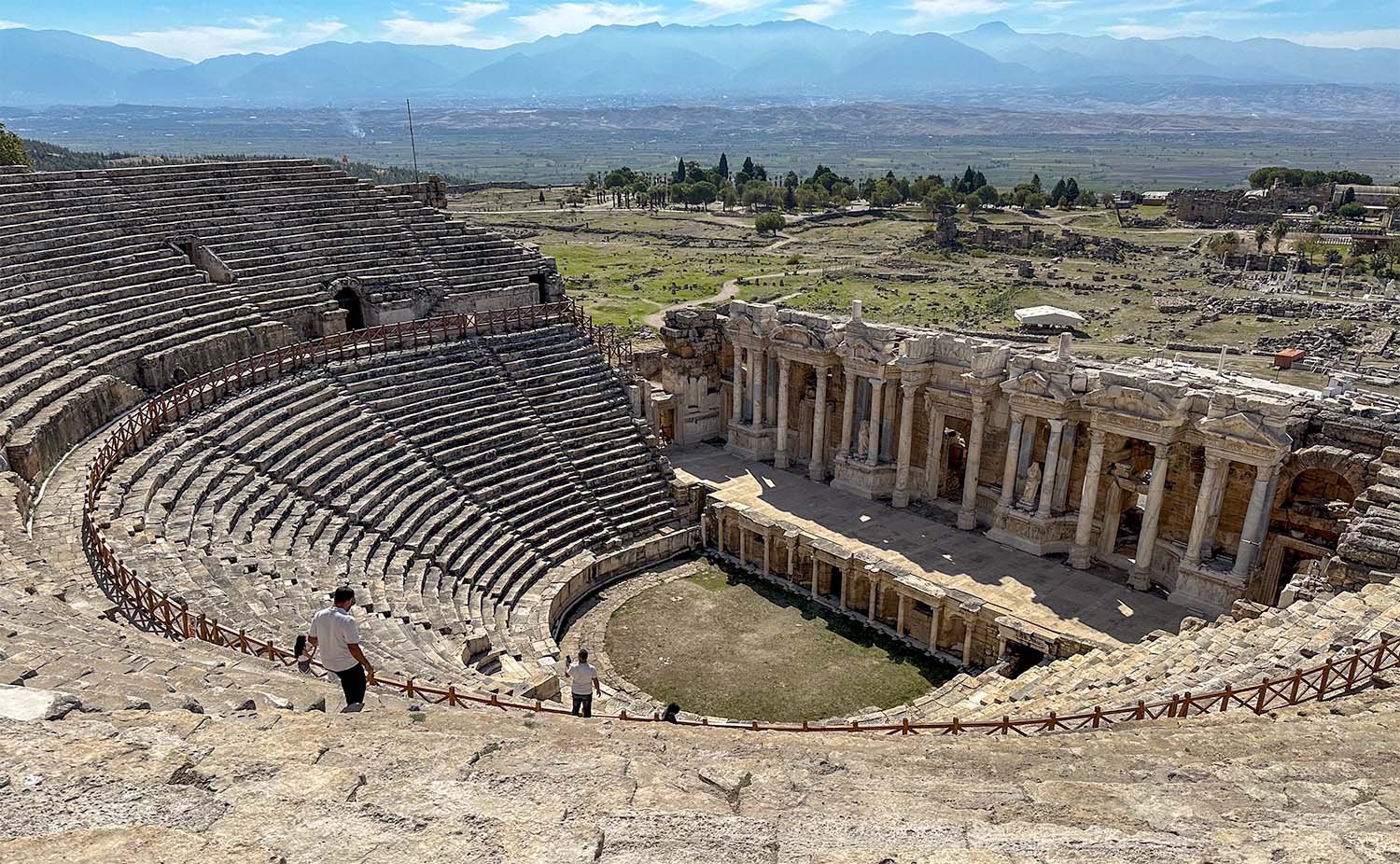 View over the Roman amphitheatre at Hierapolis in Turkiye with the Çürüksu Valley in the distance.