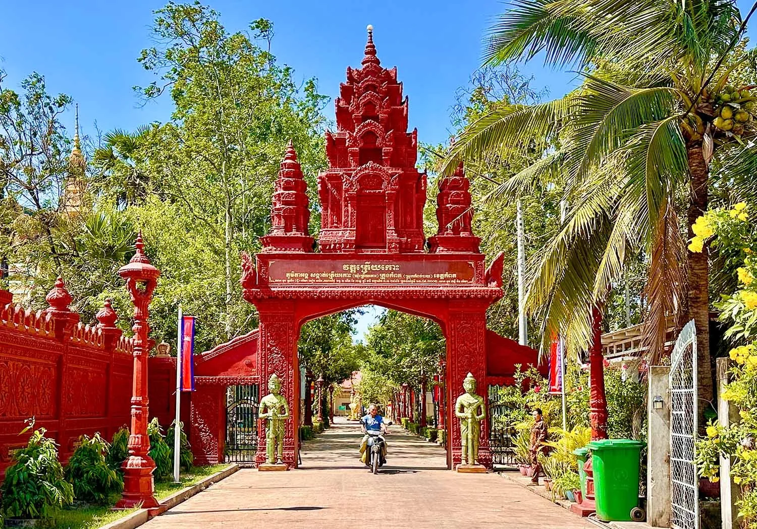 A person ride a motorcycle through an archway at the entrance to Wat Traeuy Kaoh on Fish Island, Kampot, Cambodia.