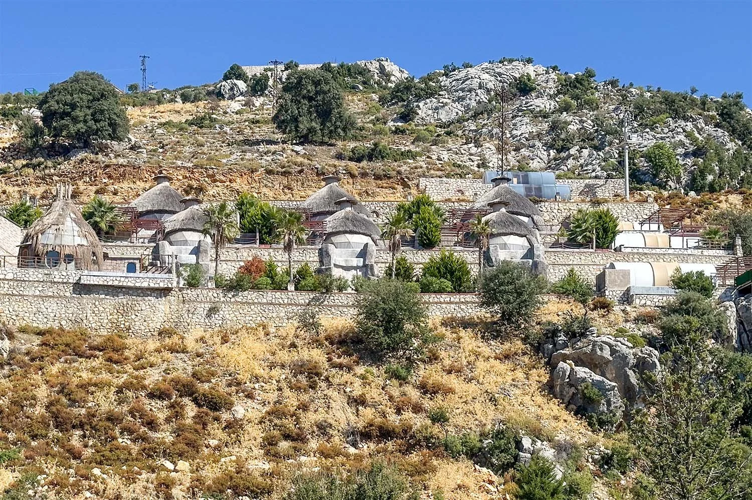 A luxury glamping resort constructed behind stone walls on a rocky and arid hillside on the Turkish Riviera south of Ölüdeniz.