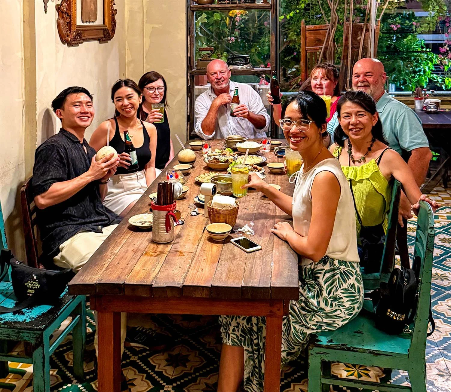 Seven tourists of different nationalities at dinner in Vietnam pose for a group photograph.