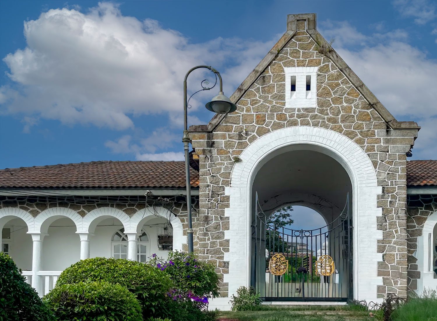 Exterior view of a classic arched gate house entrance to the colonial bungalow, Bel Retiro, on Penang Hill, Penang Island, Malysia.