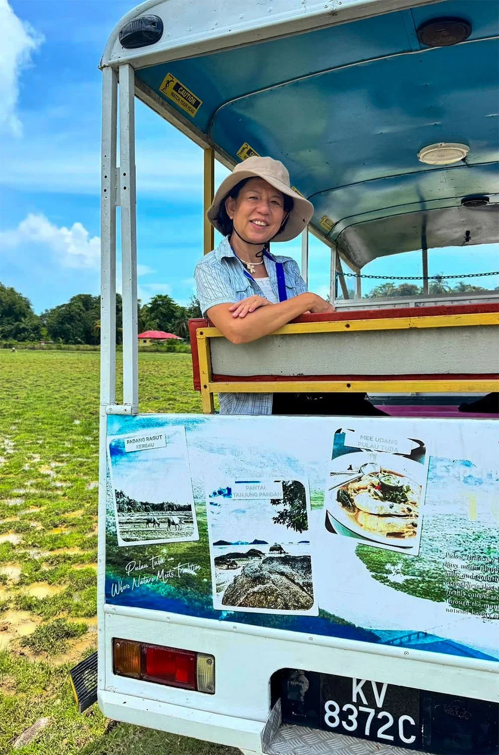 A female tourist sits at the back of an open truck for a sightseeing tour of Palau Tuba off Langkawi Island, Malaysia.
