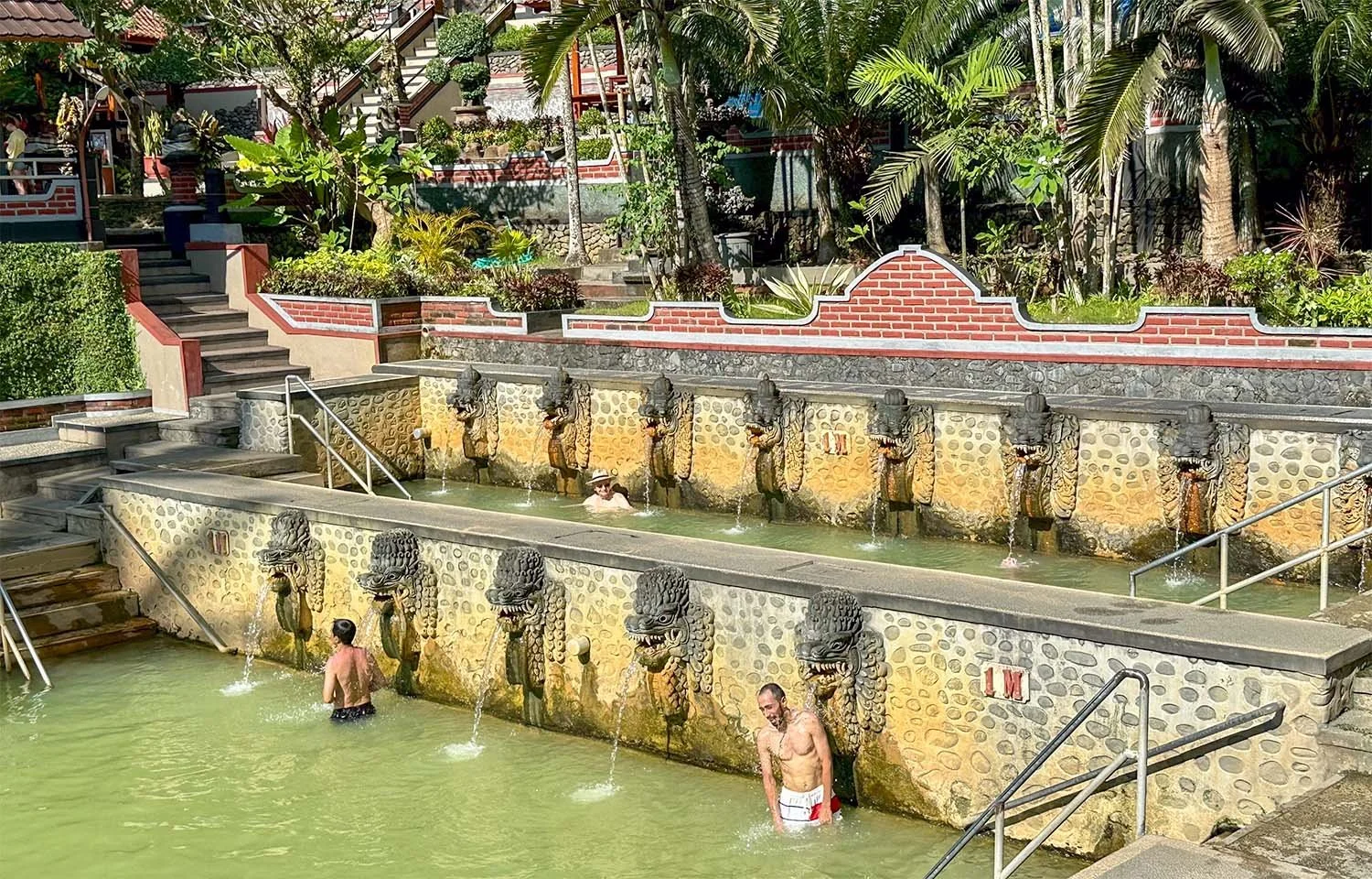 Three men bathing in the terraced polls of the Banjar Hot Spring in North Bali.