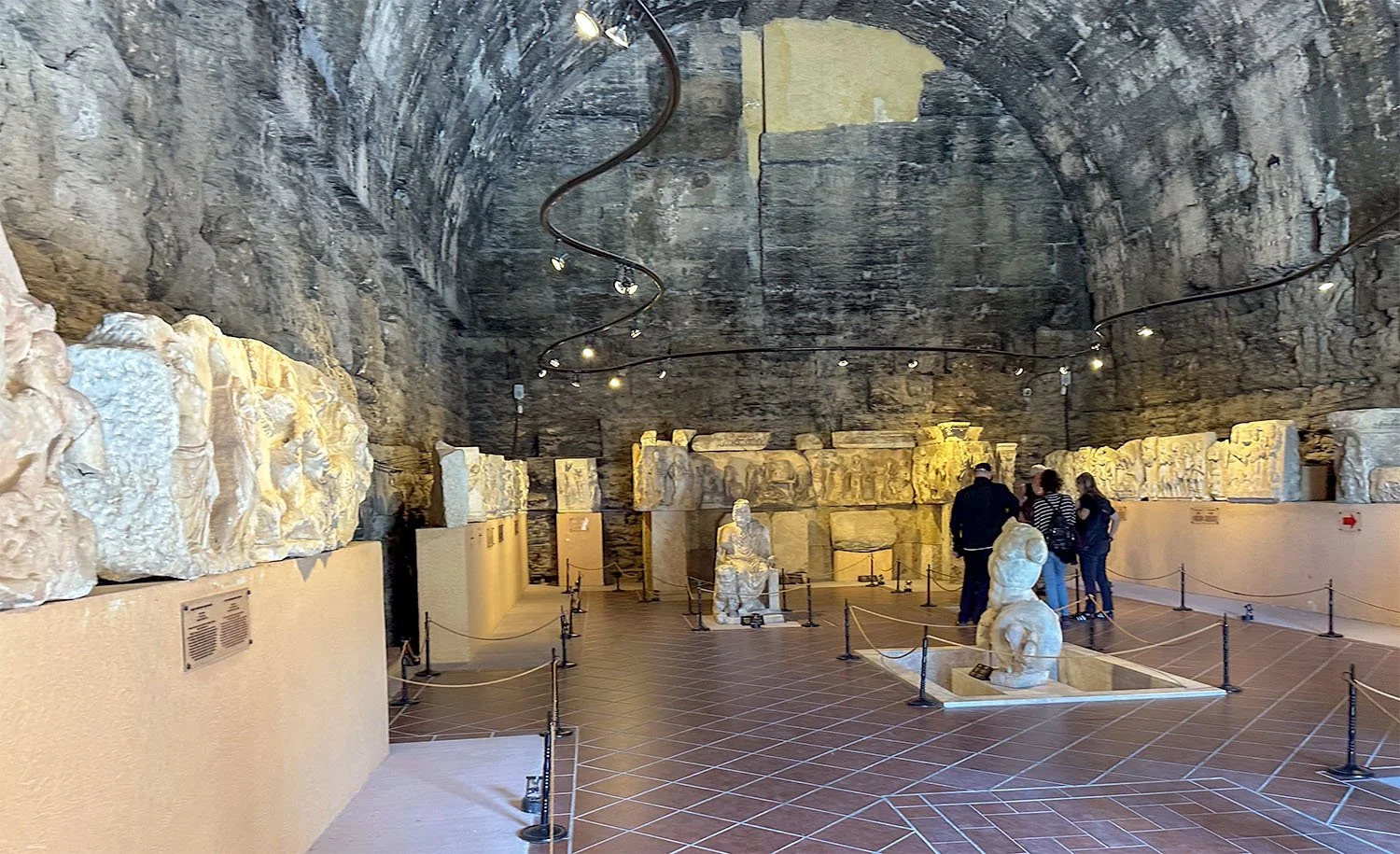 Interior view of the museum at Hierapolis, Turkiye, which is inside an ancient structure with a curved stone roof.