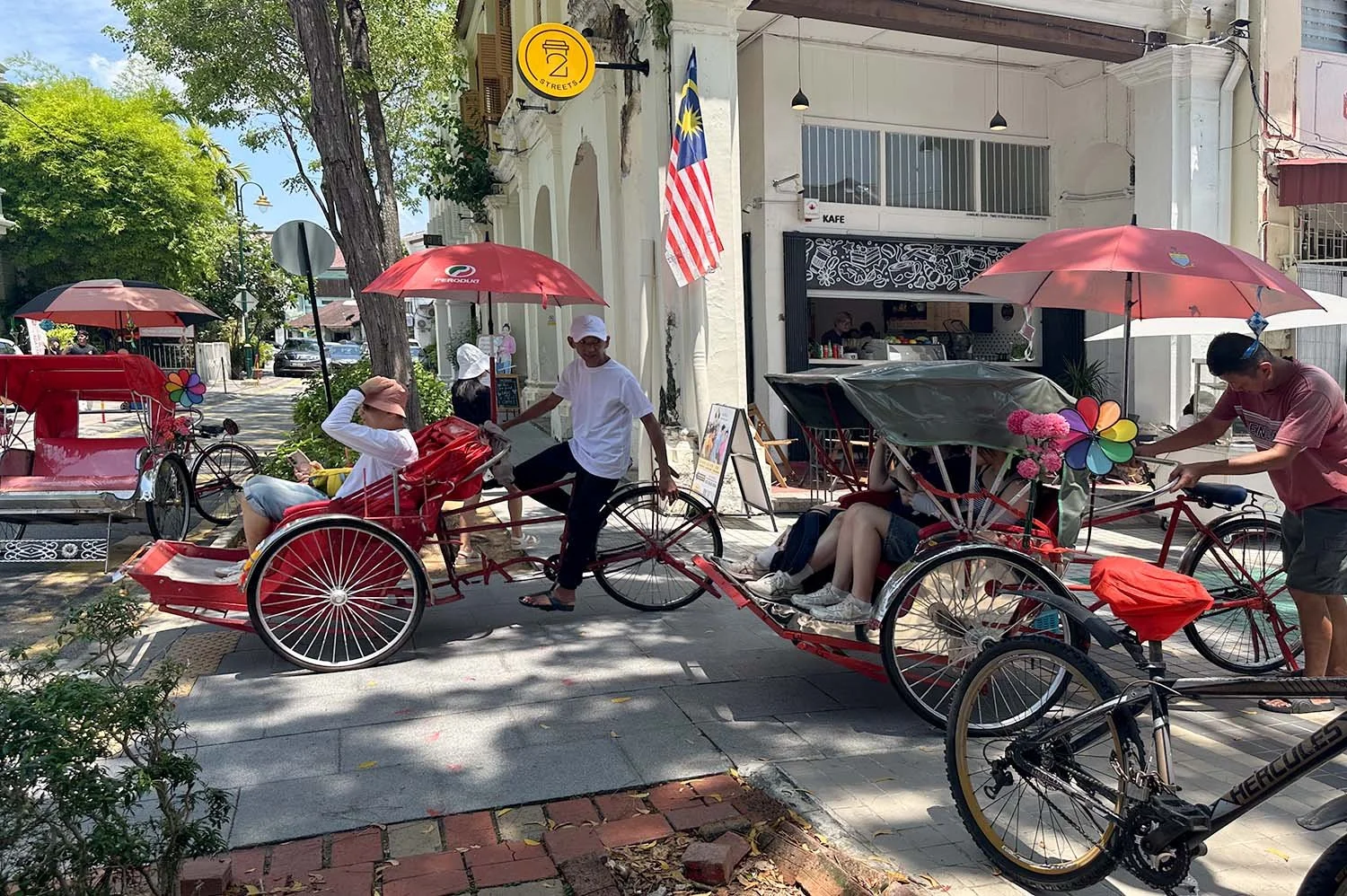 Trishaw drivers taking tourists on heritage tours in George Town, Penang, Malaysia.