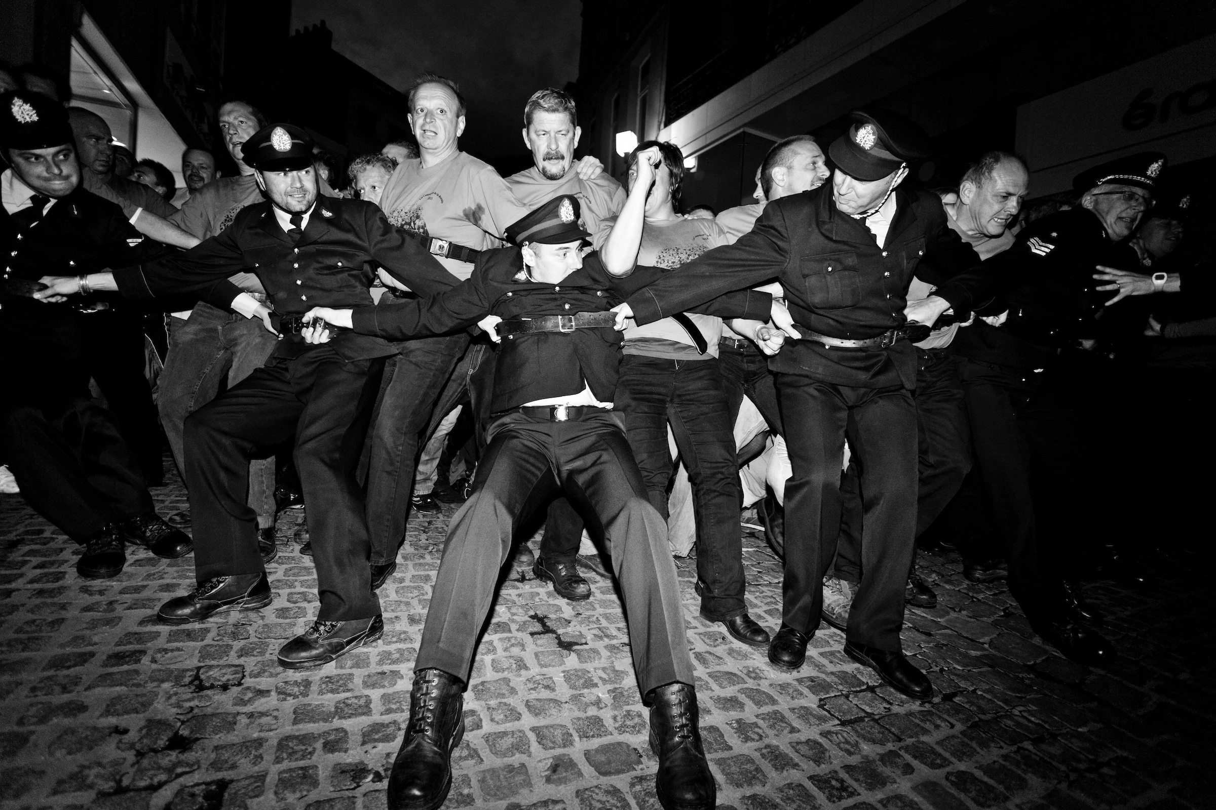 The crowd is delirious during the Ducasse of Mons. Policemen on duty are wearing their old uniform holding the pushing crowd. Belgium on June 2011.