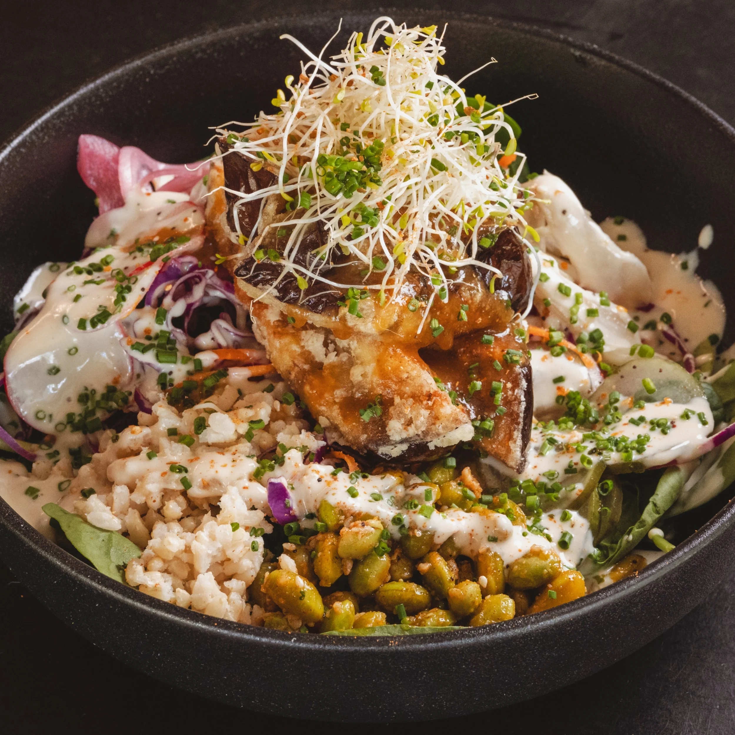 Fried tempura eggplant bowl with grains, greens and sauce at ALL DAY café in West End Brisbane