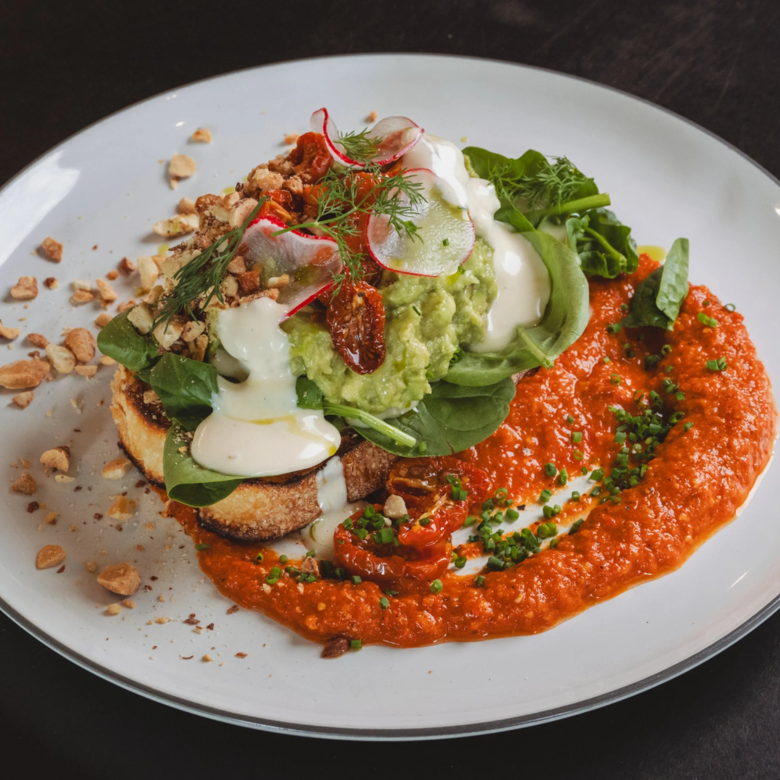 Avocado toast with greens, sauce and toasted sourdough at ALL DAY café in West End Brisbane