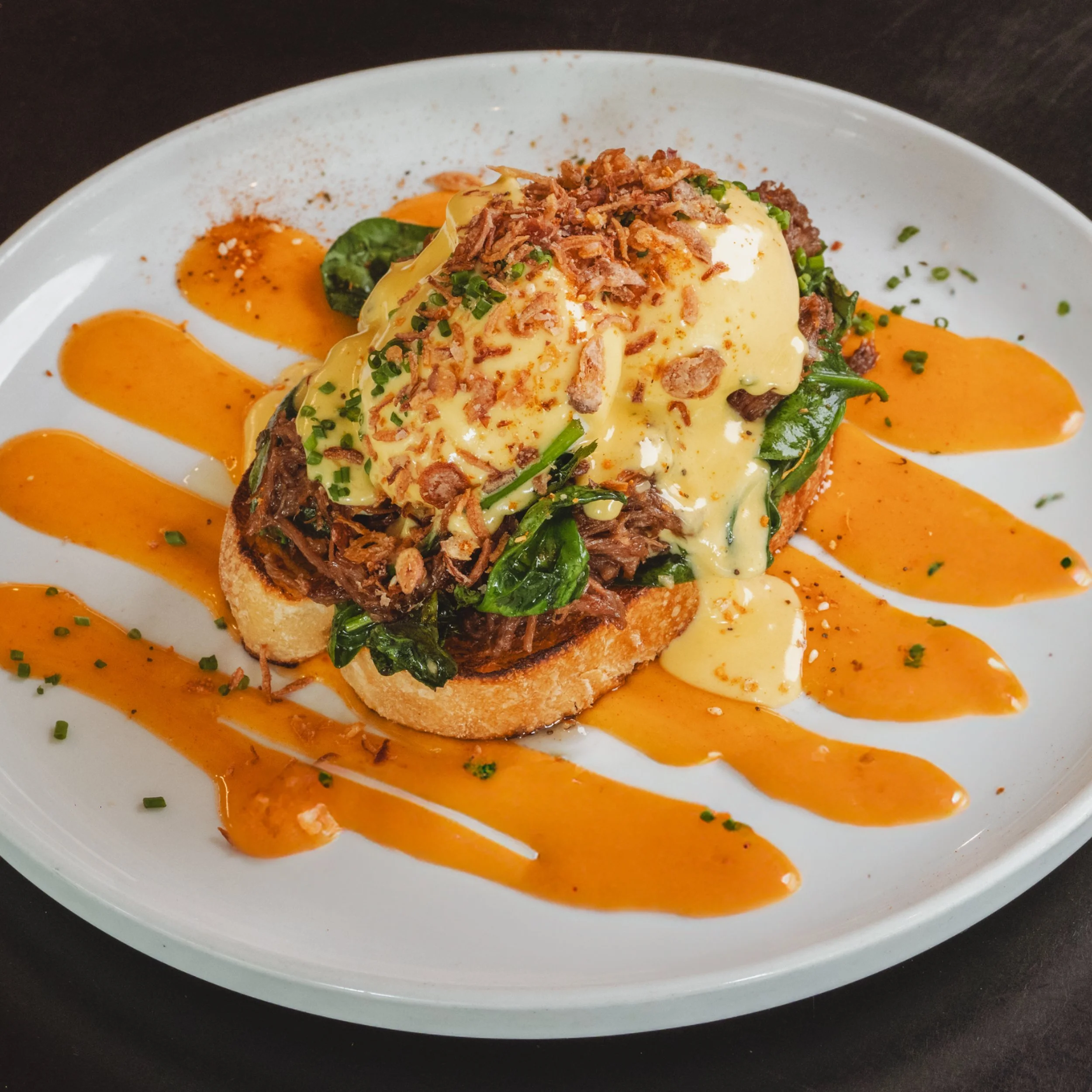 Pulled beef eggs benedict with hollandaise on sourdough at ALL DAY café in West End Brisbane