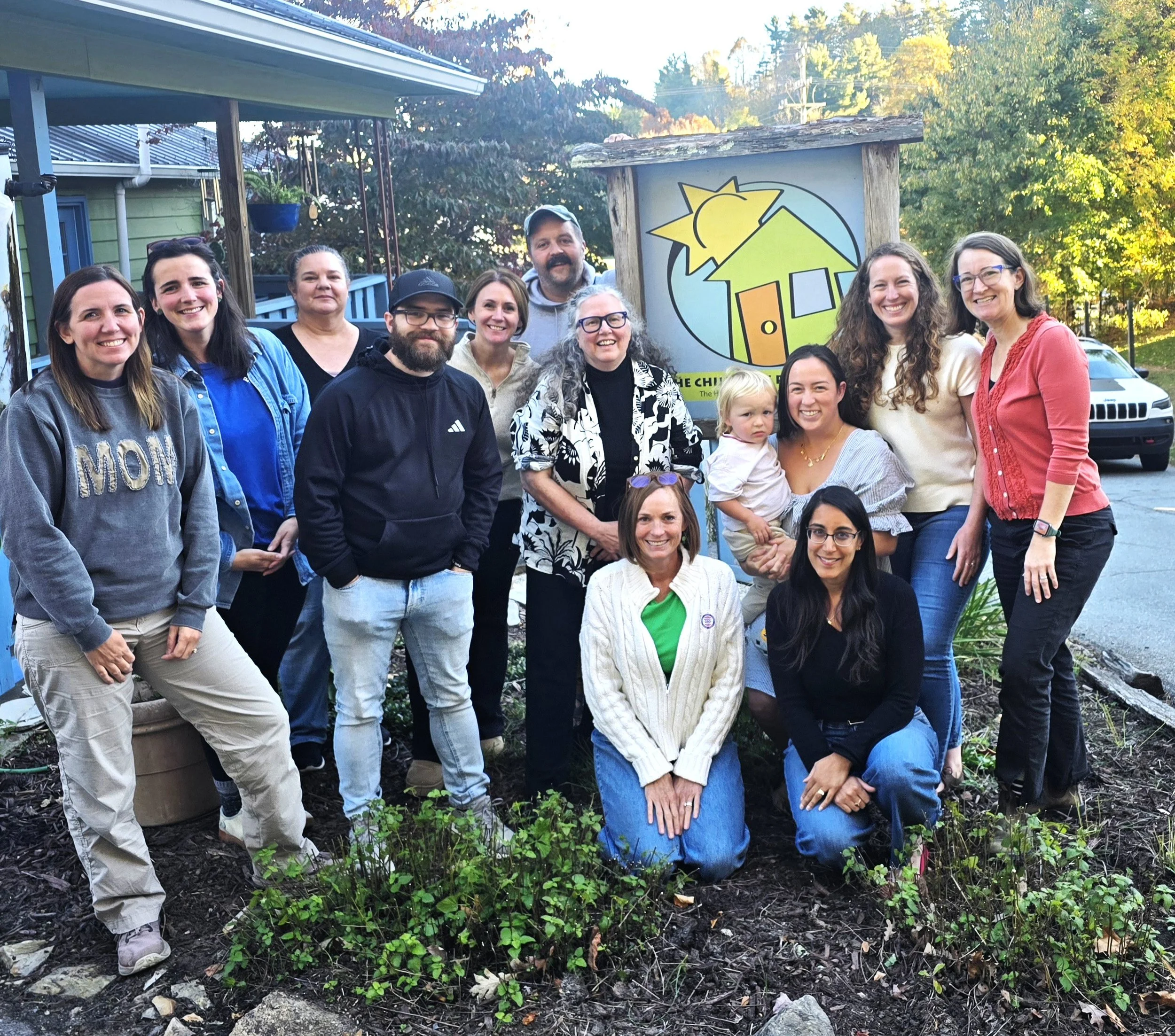 Members of the Playhouse board and staff around the Playhouse sign.