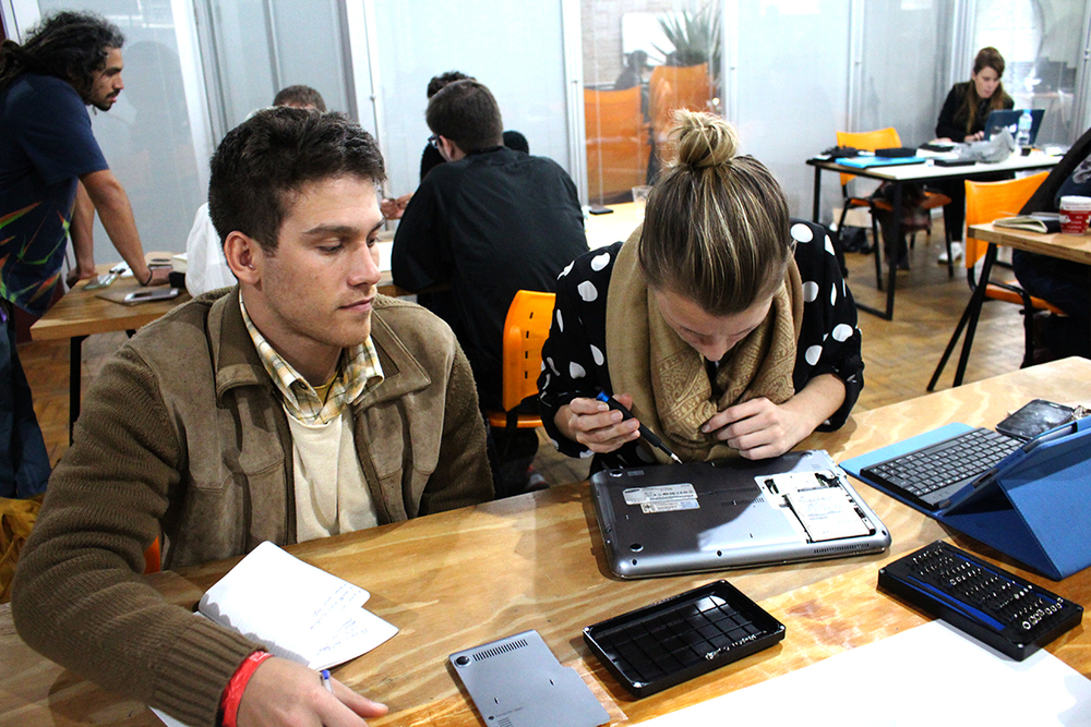 Victor and Thessa take apart a broken laptop