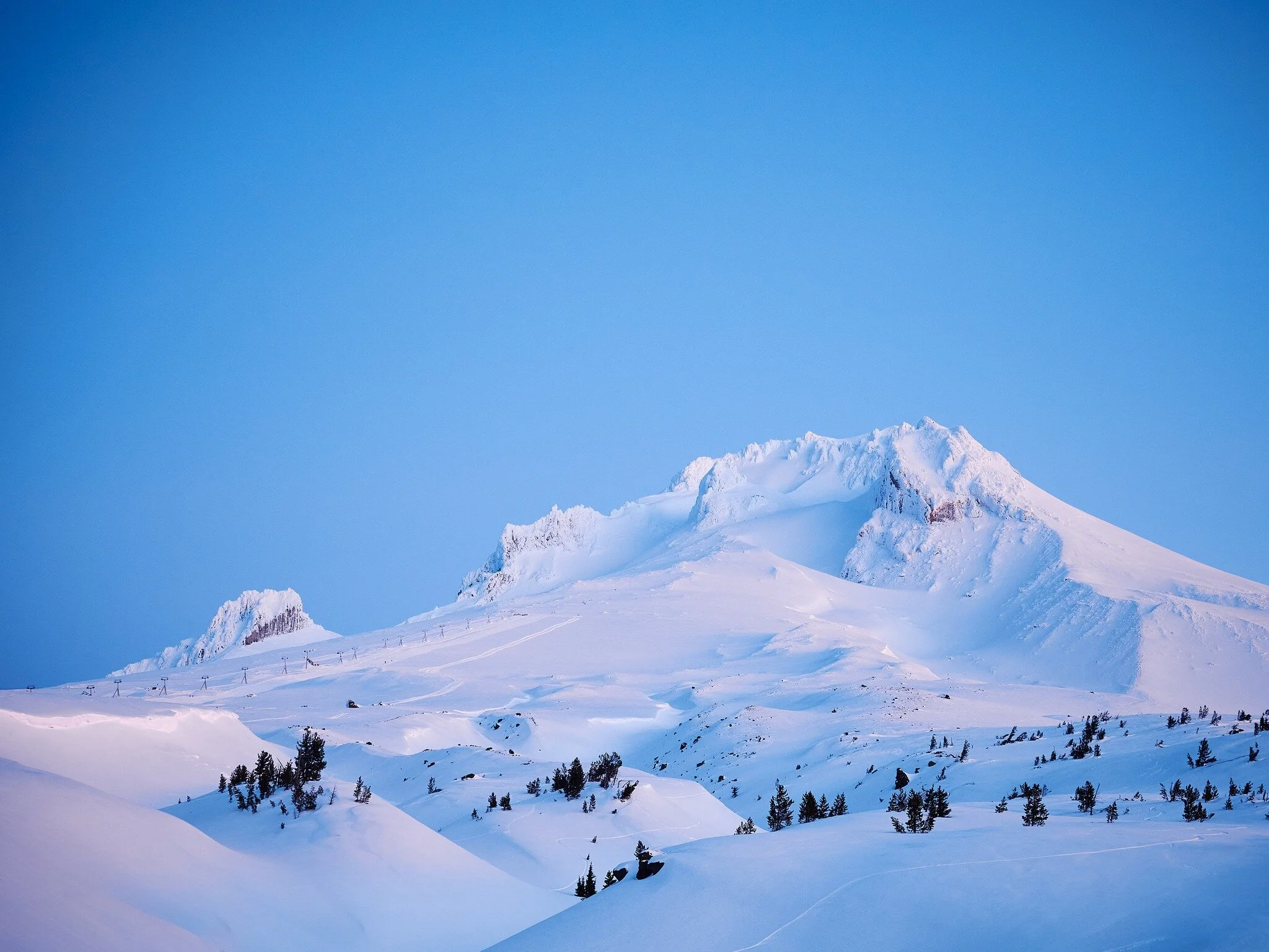 In due time, the mountain will once again be doused in powder ❄️🏔️.

The alpenglow kissing the mountain peaks 🌄 

Gentle curves holding a tranquil stillness 🤍 in the morning light ☀️.