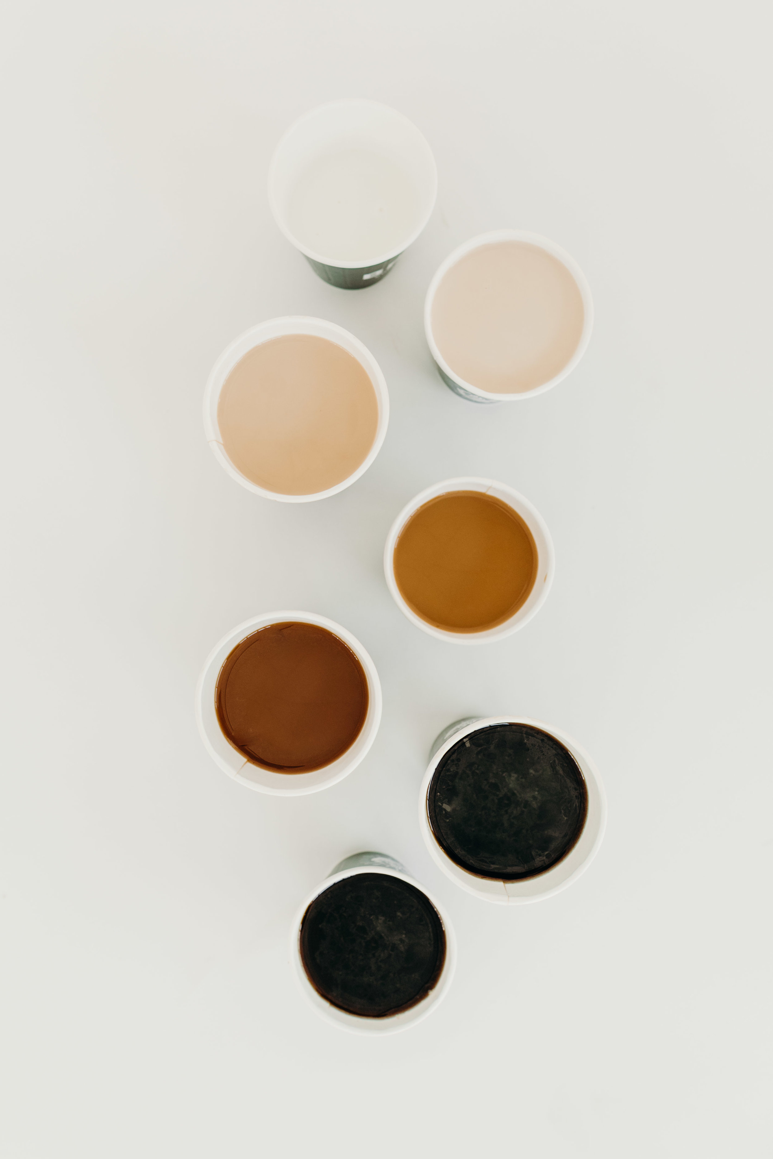 Overhead view of various beverages in paper cups from Brash Coffee