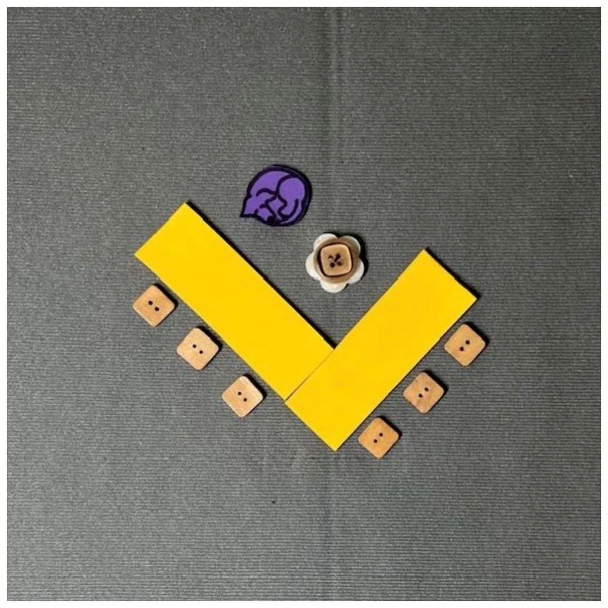 Yellow rectangles representing tables setup in a L-shape with chairs around the outside. Icons on the opposite side of the tables from the other chairs showing where a rolling chair and guide dog will be.