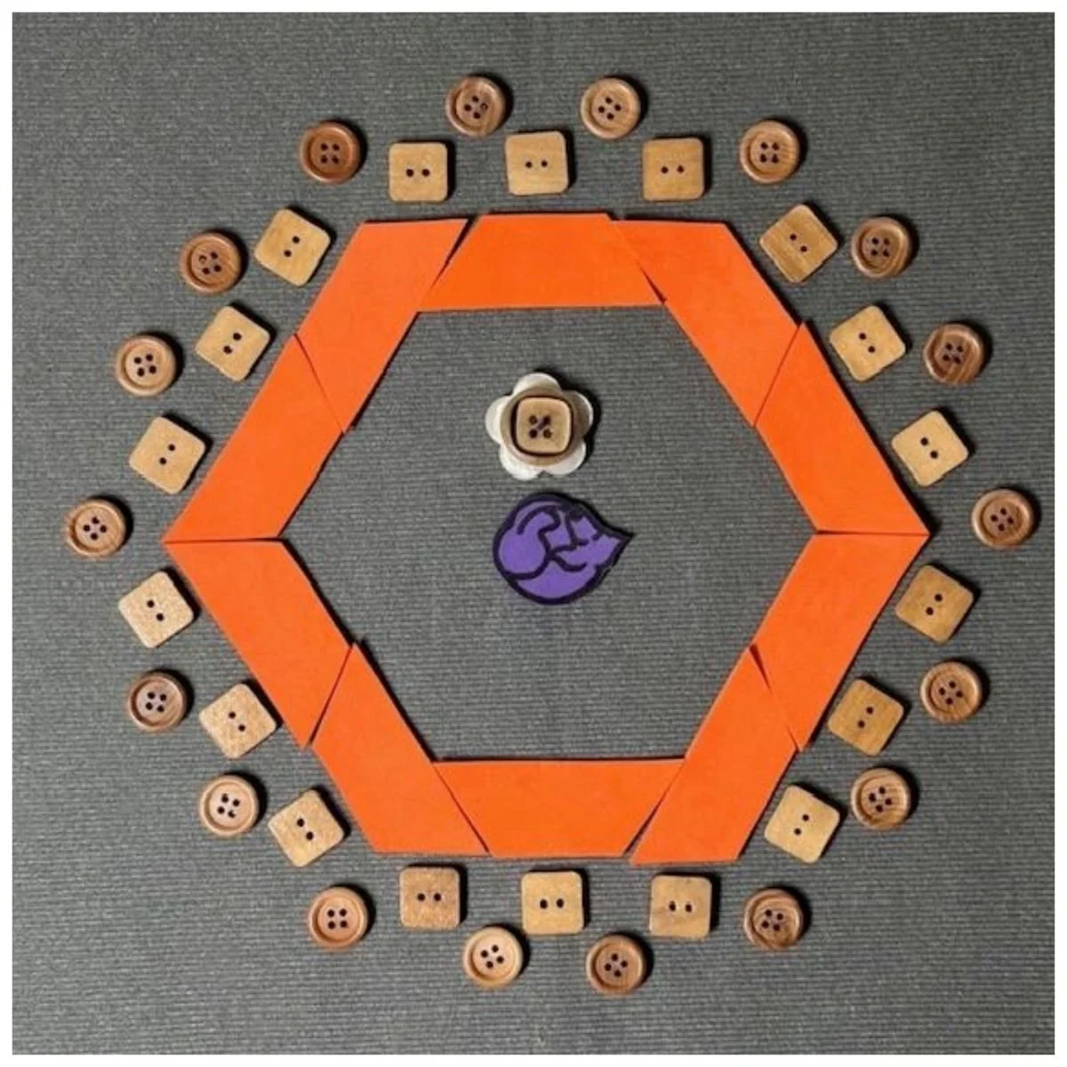 Rectangles representing tables set in a hexagon shape with chairs and/or standing people around the outside. A rolling chair for the presenter  will be in the center.