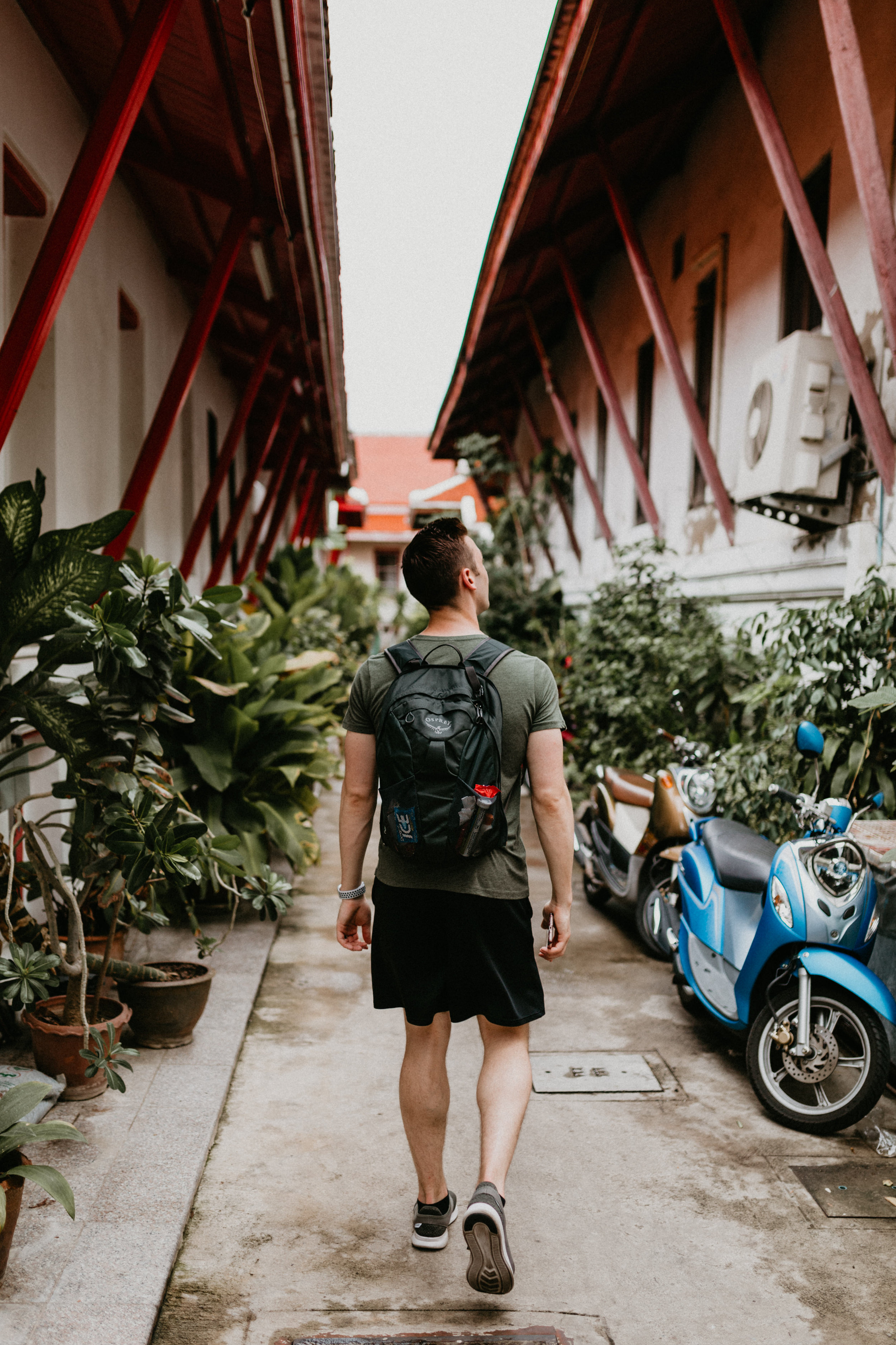 man walking towards Wat Arun with moped.jpg