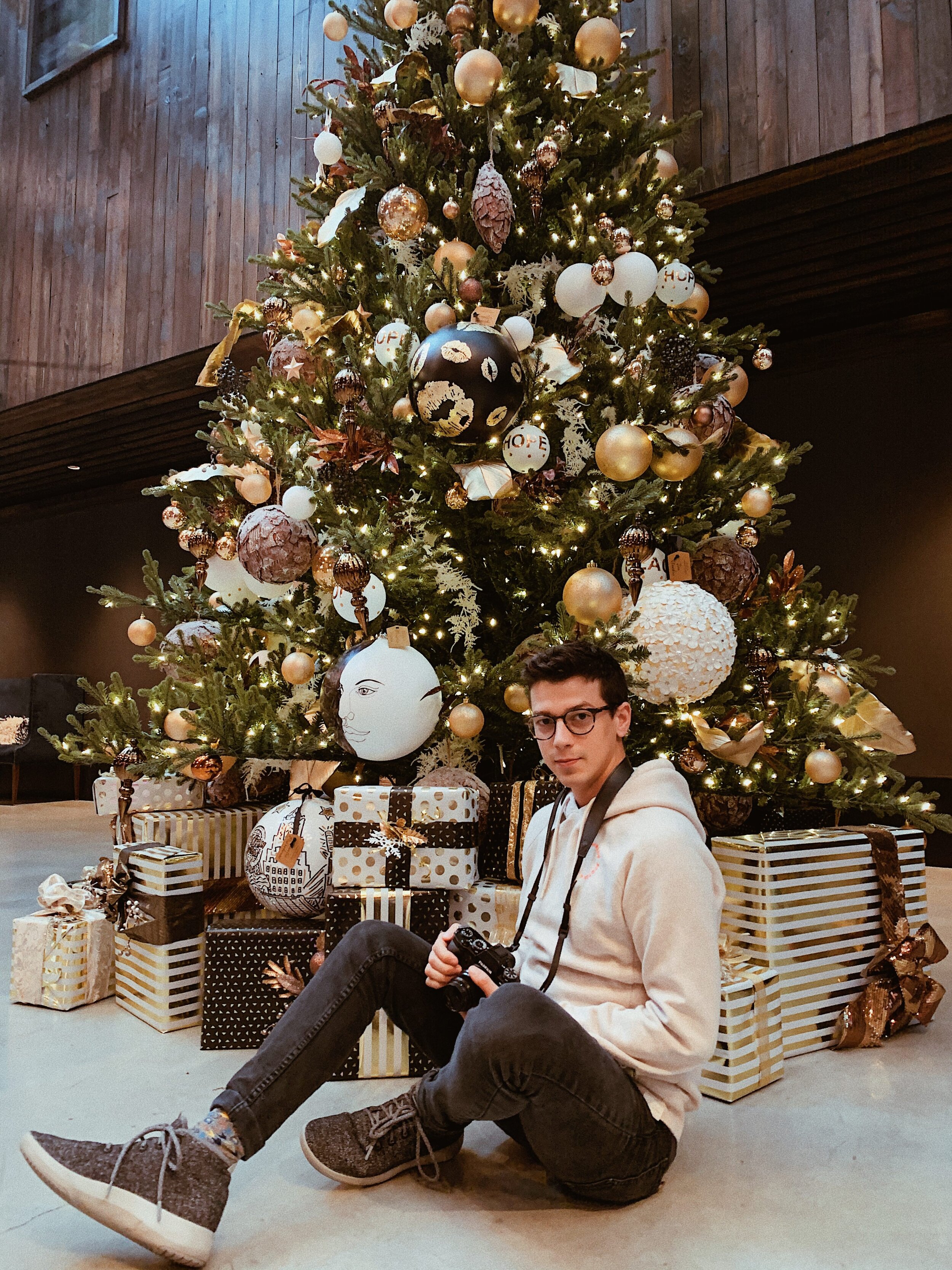 Matthew sitting in front of a christmas tree at Crossroads hotel Kansas City.JPG