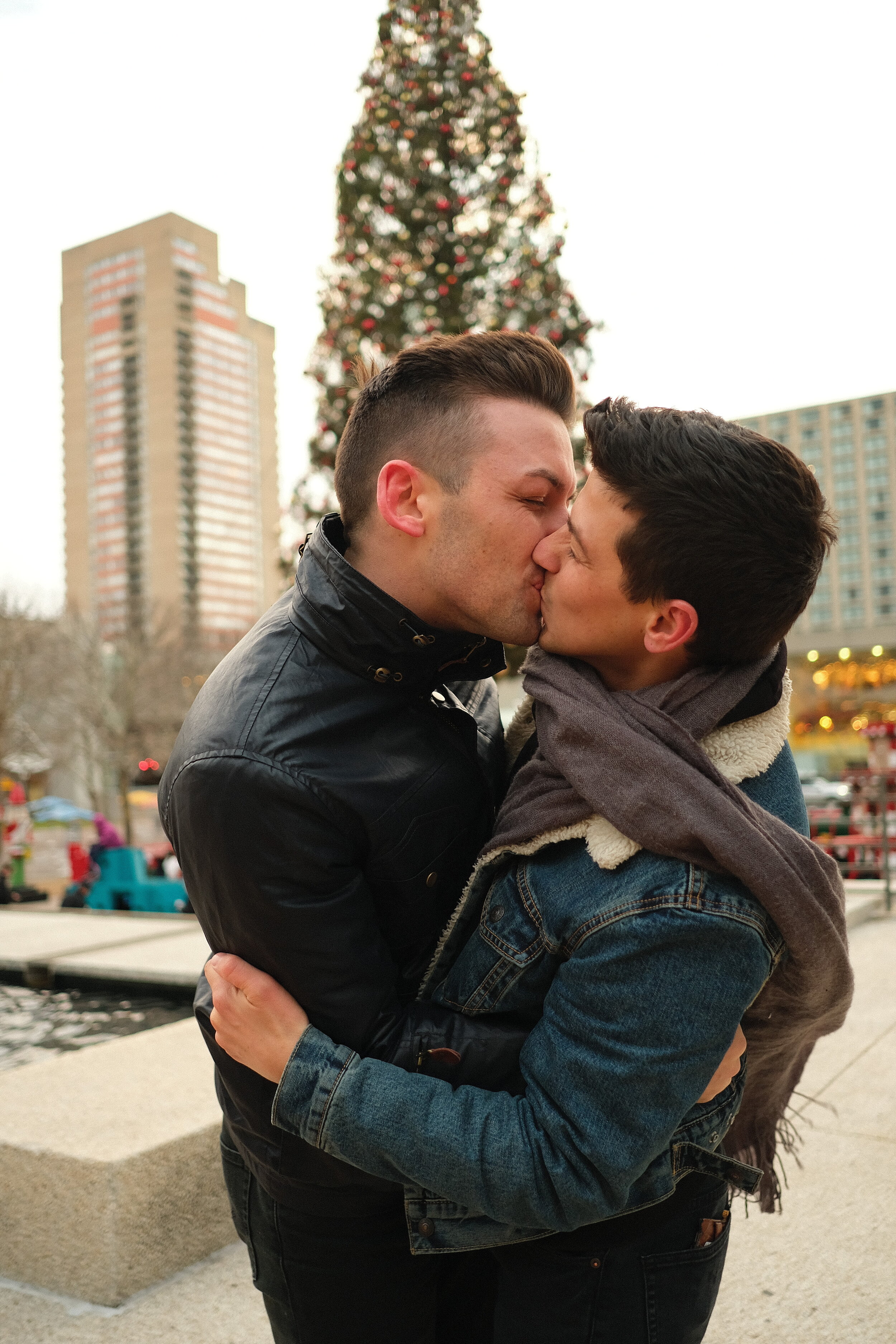 Husbands kiss in Crown Center in front of the Christmas Tree.JPG