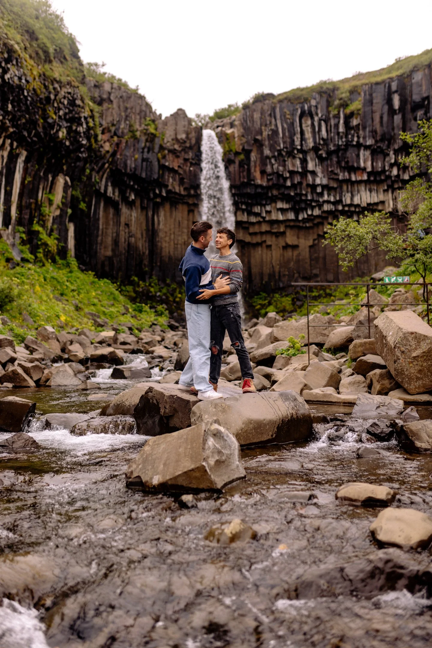 Michael and Matt standing in front of a waterfall in Iceland.