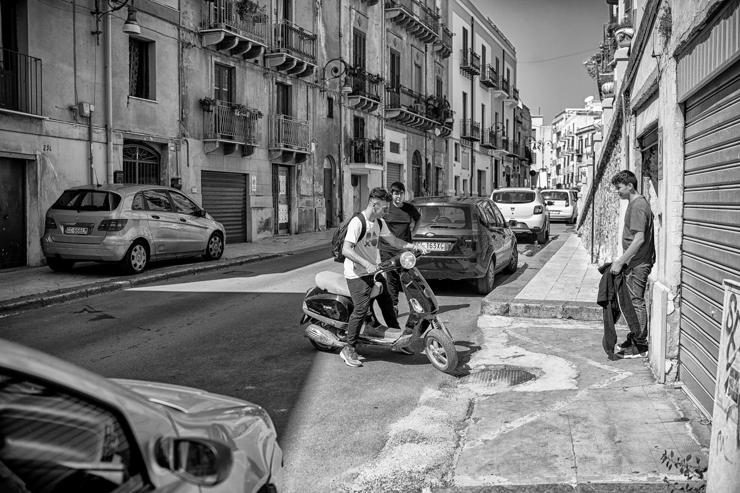 strolling_street_portrait_Sciacca_Sicily_three_boys_and_a_scooter_NIX_filter_B&W_9052.jpg