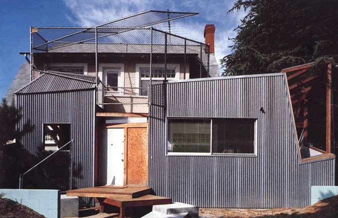 Gehry Residence in Santa Monica, 1978. One of the earliest examples of deconstructivism as can be seen in its angular forms, the reappropriation of commonplace materials like plywood, corrugated steel, and chain-link fence show a connection to postmodernism. Image Source: ArchDaily