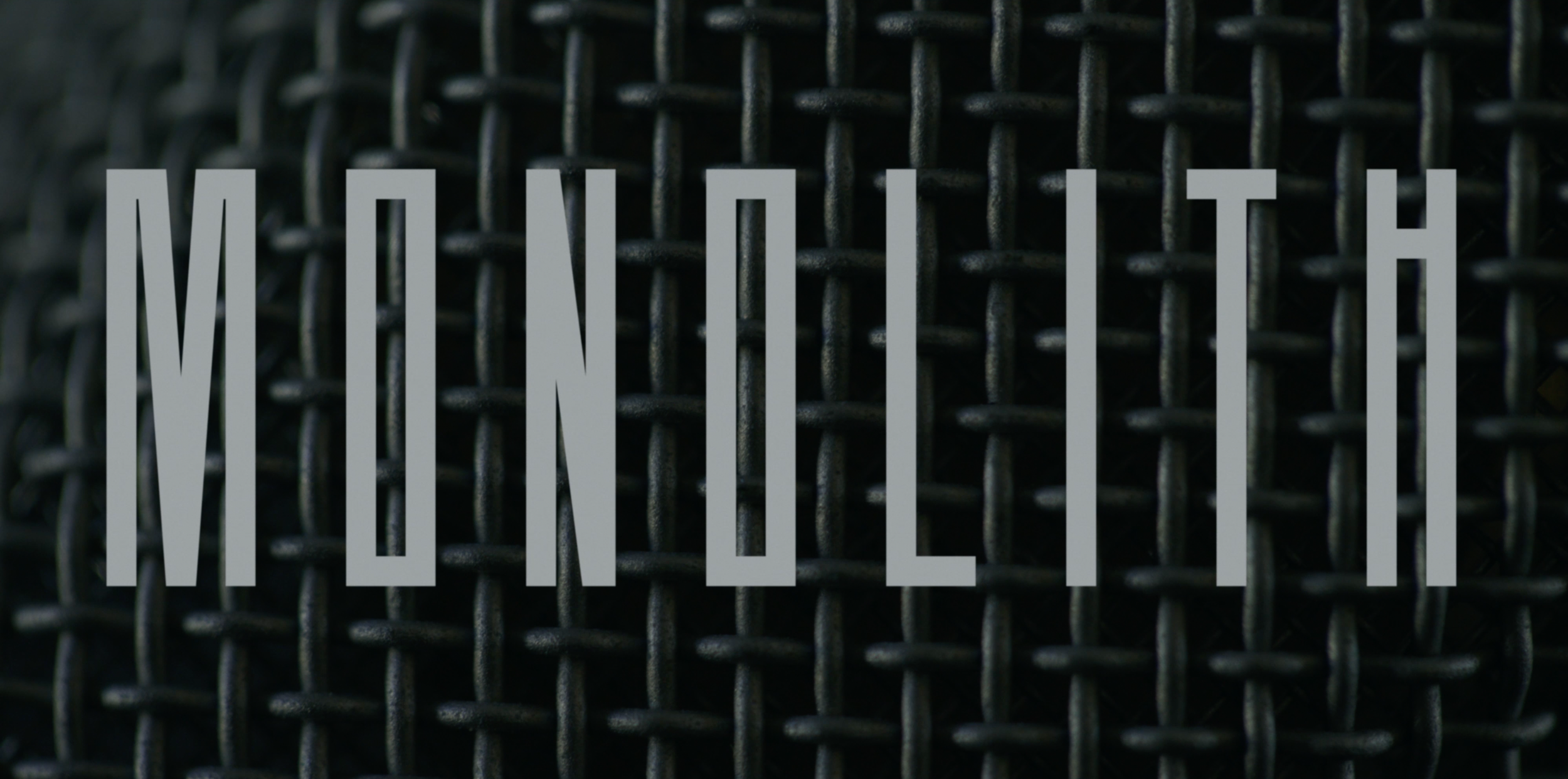 Monolith title card over a macro shot of the podcast microphone grille — a film told through sound.