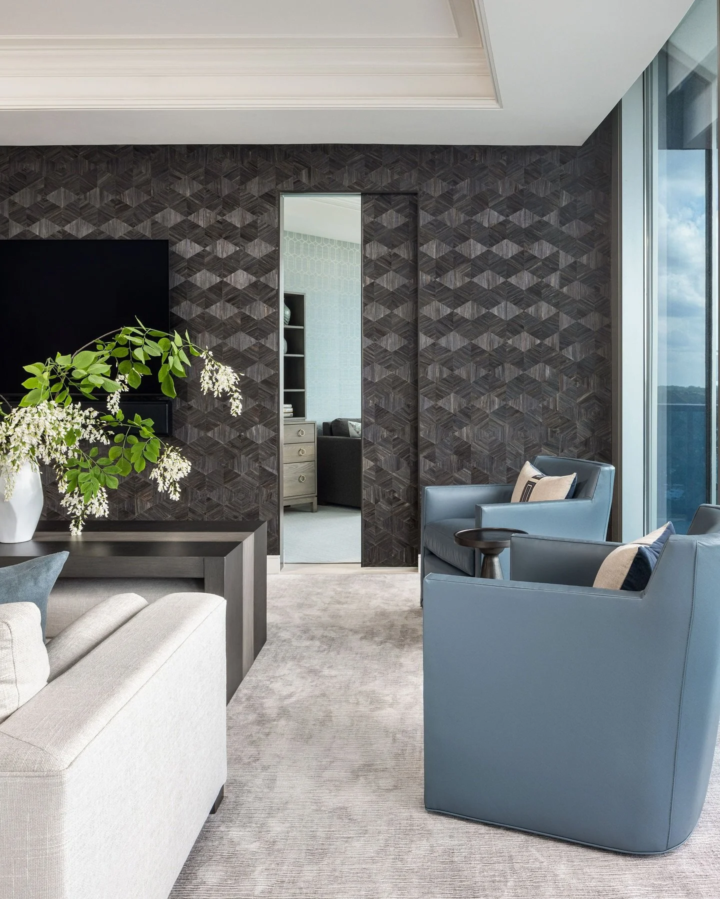 WALLPAPER WEDNESDAY: For our Rosslyn penthouse project, we added a dramatic focal wall to keep the TV from stealing the show. This natural, geometric wall, covering by @phillipjeffriesltd adds both dimension and weight to the room. 
BONUS: Look clos