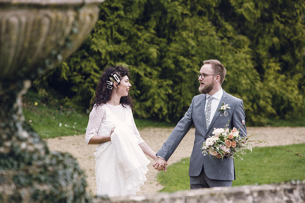 Bride and groom holding hands at Orchardleigh Estate