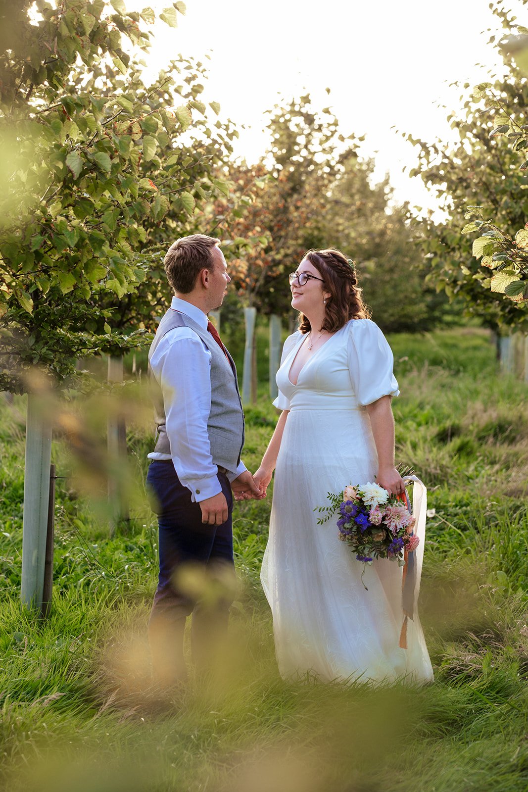Newlywed couple photographed in a vineyard at golden hour