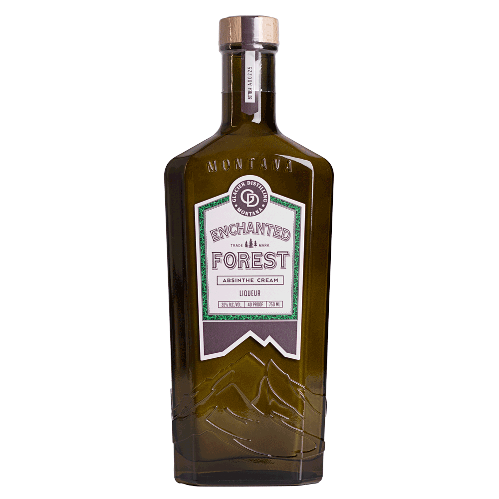 A tall, brown glass bottle of Enchanted Forest absinthe cream liqueur with a wooden cork and a label featuring green and purple accents.