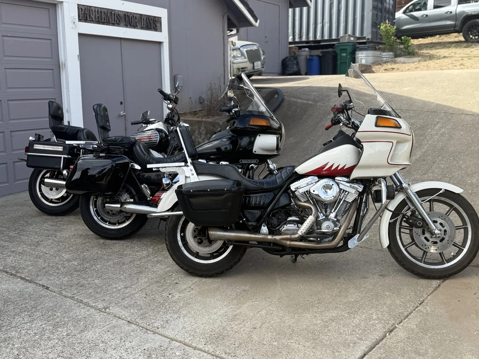 Three Harley-Davidson FXR motorcycles lined up outside the Thunder Road Motorcycles shop.