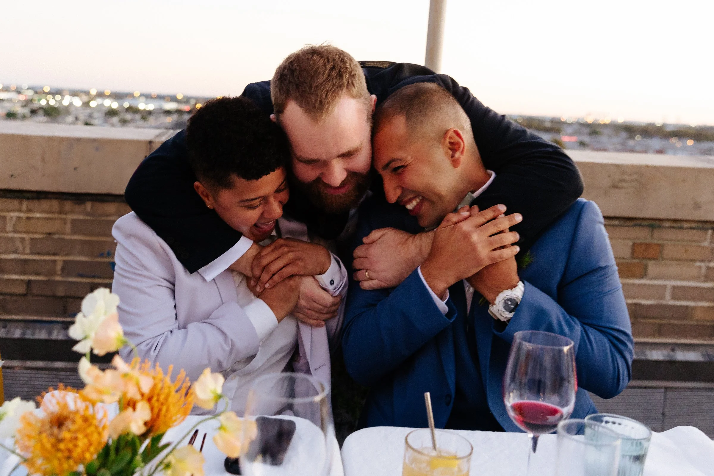 A groom hugging his friends after getting married.