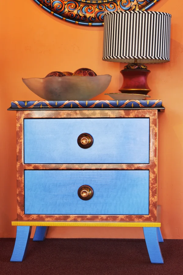 Bohemian chest houses traditional lamp with ticking stripe shade Design Thought: When purchasing small tables always measure the height and refer to standard guidelines. For that eclectic feel mix the style of the nightstands while maintaining the same height on either side of the bed.