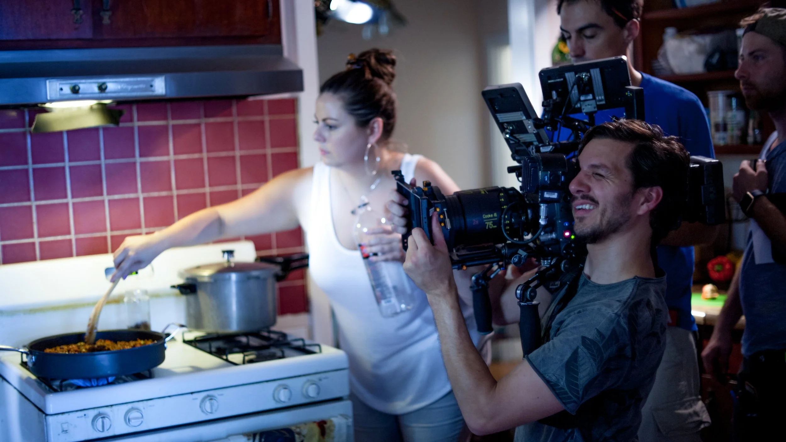 Director Claudia Murray stirs a skillet of picadillo while Director of Photography Ben Gaskell captures the scene.