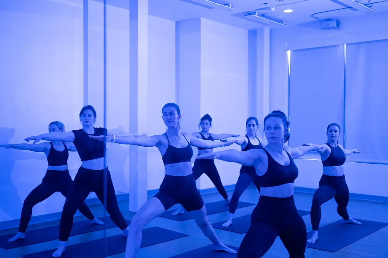 Members in warrior 2 pose during Midtown Yoga class.