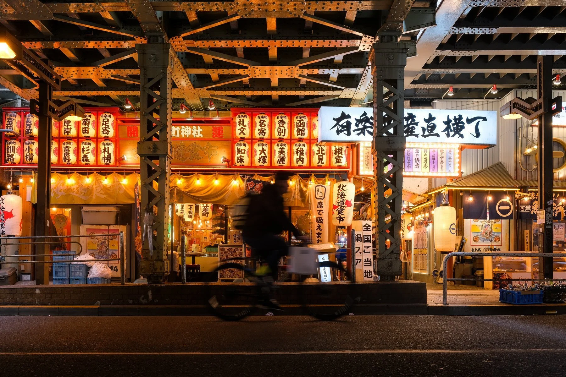 Biker speeds by a yokocho in Tokyo, Japan